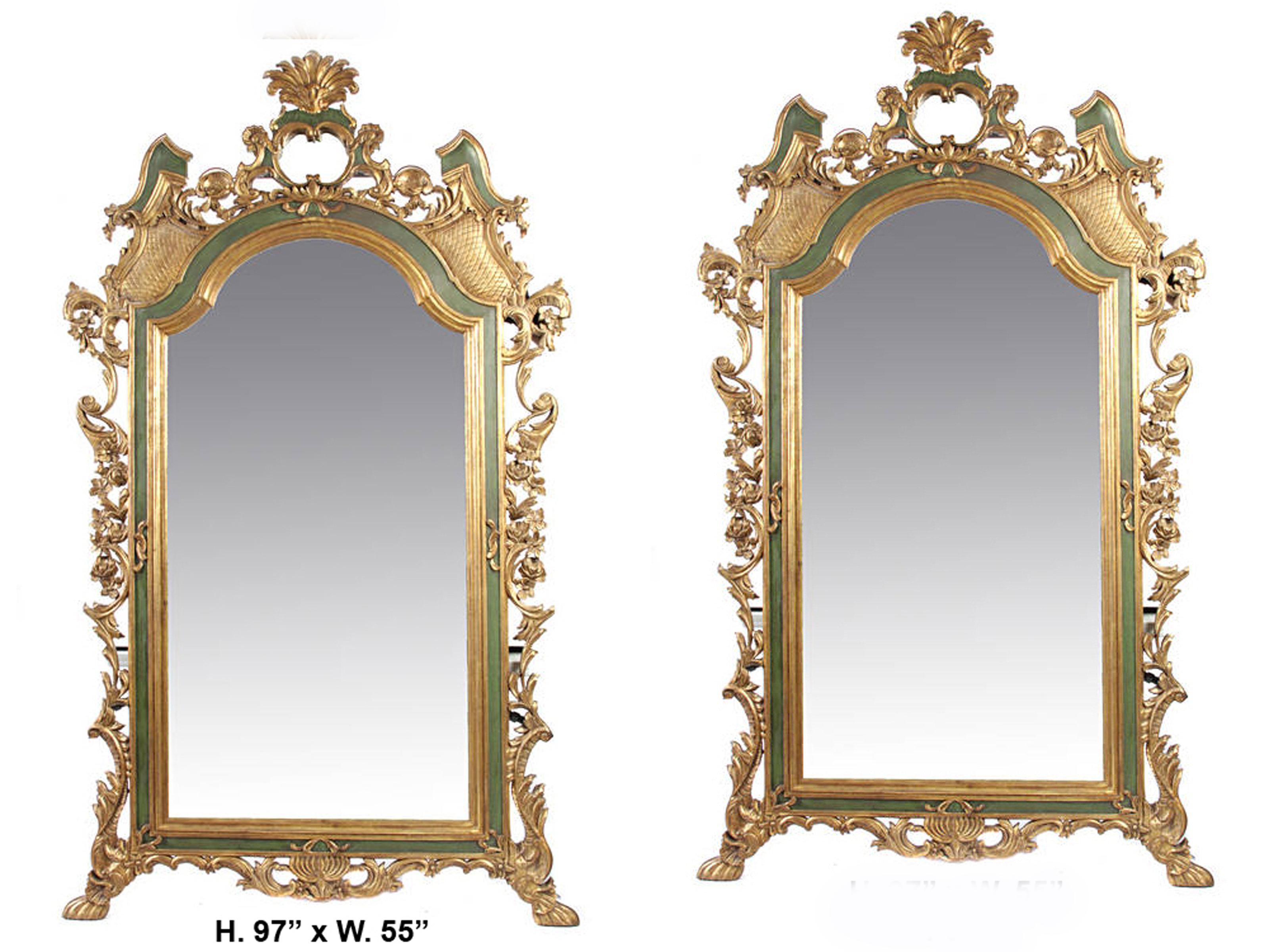 Impressive large pair of Italian Rococo style parcel gilt green painted mirrors,
first half of 20th century.

The beautiful mirrors are surmounted with a giltwood foliate palmette, over parcel gilt and green painted Rocaille motif crown with