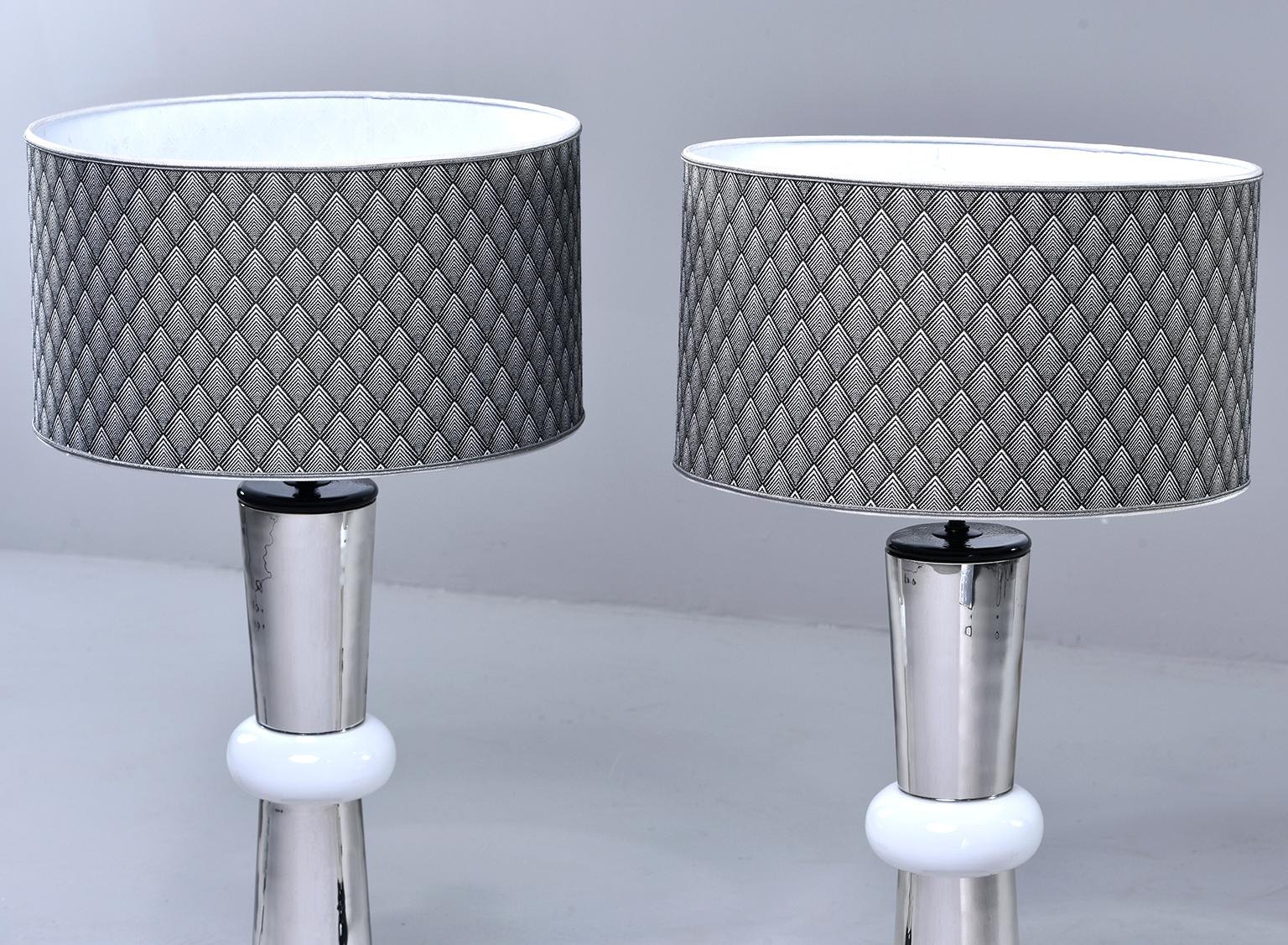 Pair of Italian glass lamps feature a black glass base and silver glass columns accented with white glass rings, circa 1980s. Fabric shades are included and have black and white woven chevron pattern. Sold and priced as a pair. New wiring for US