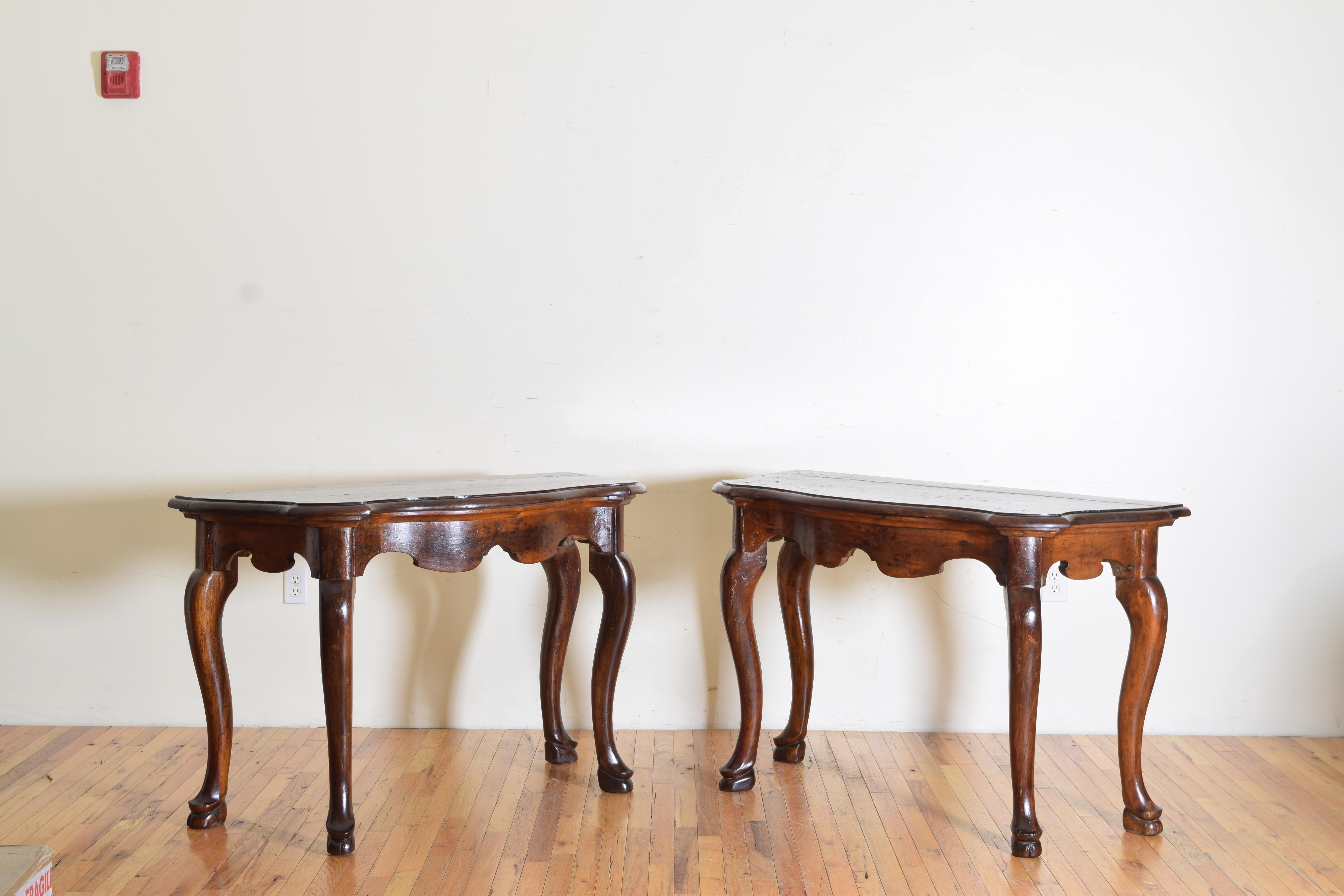 These large and impressive console tables are completely original, having serpentine shaped tops above conforming frames with shaped aprons, the cabriole legs terminating in large hoof feet.