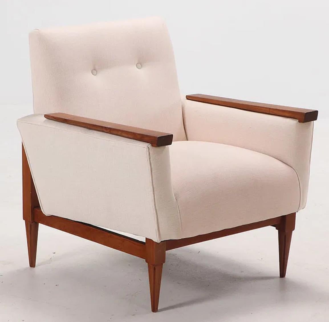 Cette paire de fauteuils fait preuve d'une simplicité raffinée, avec une inclinaison subtile de la base et de l'assise qui ajoute une élégance discrète. La base en bois prolongée reflète les détails en bois appliqués sur les bras, créant ainsi un