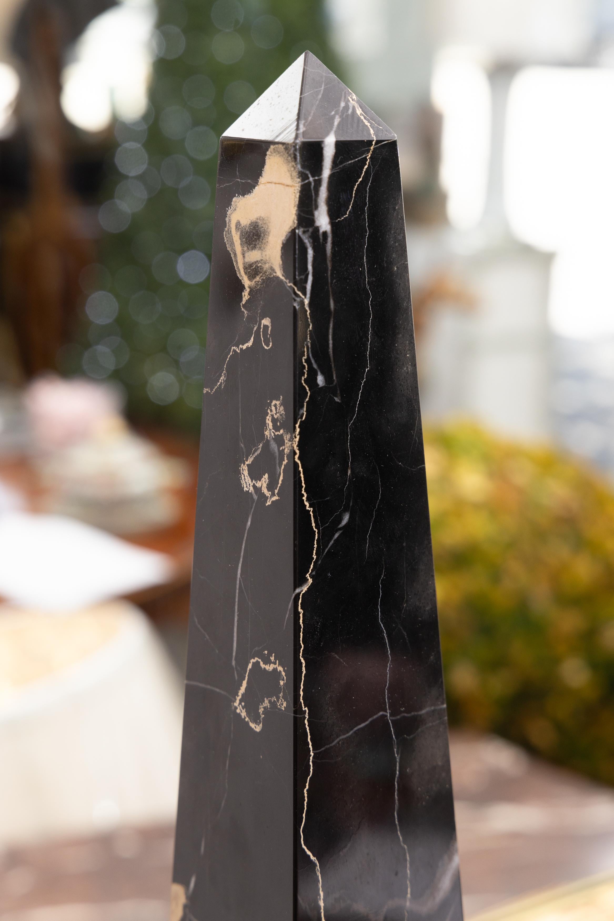 This is a stately pair of Italian black variegated marble obelisks .