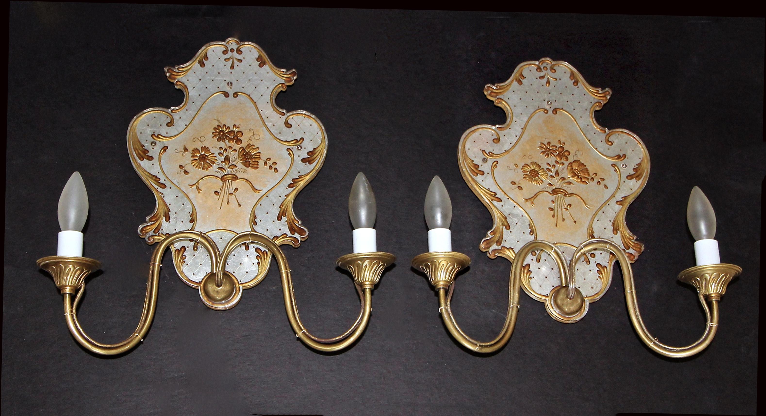 Pair of Italian Venetian églomisé floral or flower motif 2 light brass wall sconces. The detailed egolmise is applied to the reverse side of plexiglass, mounted against a wood backing. Each sconce uses two candelabra size bulbs. Newly wired.