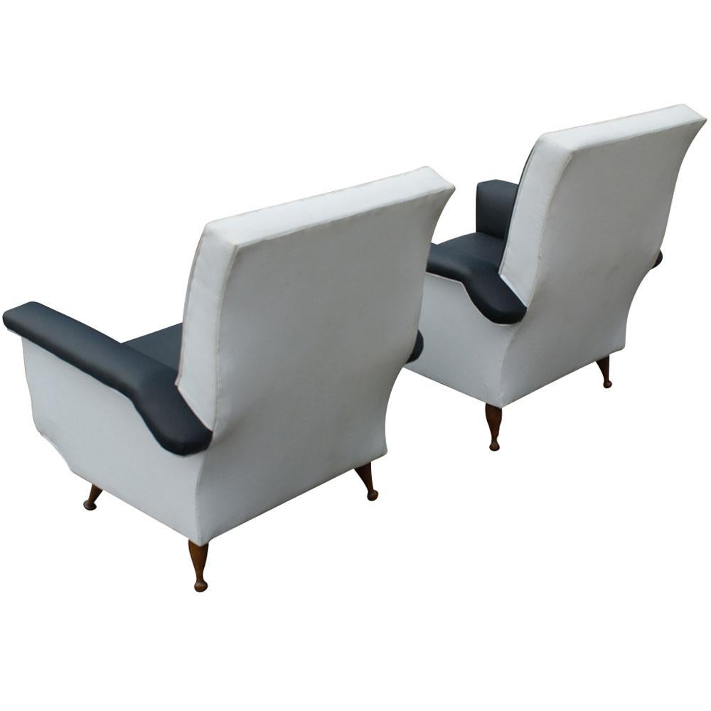 Midcentury black and white lounge chairs

Walnut tapered legs, black and white vinyl upholstery

Measures: 28
