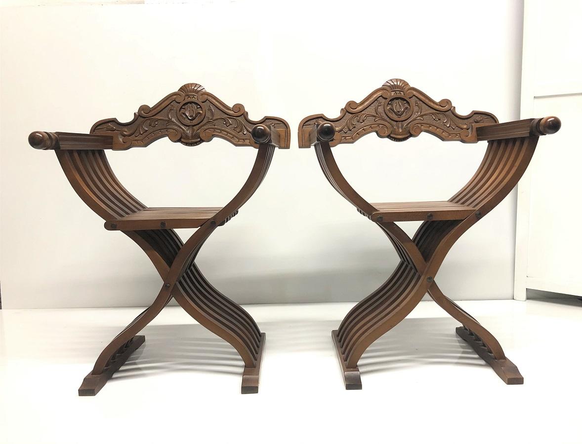 Pair of Italian walnut Savonarola folding chairs. The chairs have a nicely carved back, green loose cushion seats and fold for easy storage.