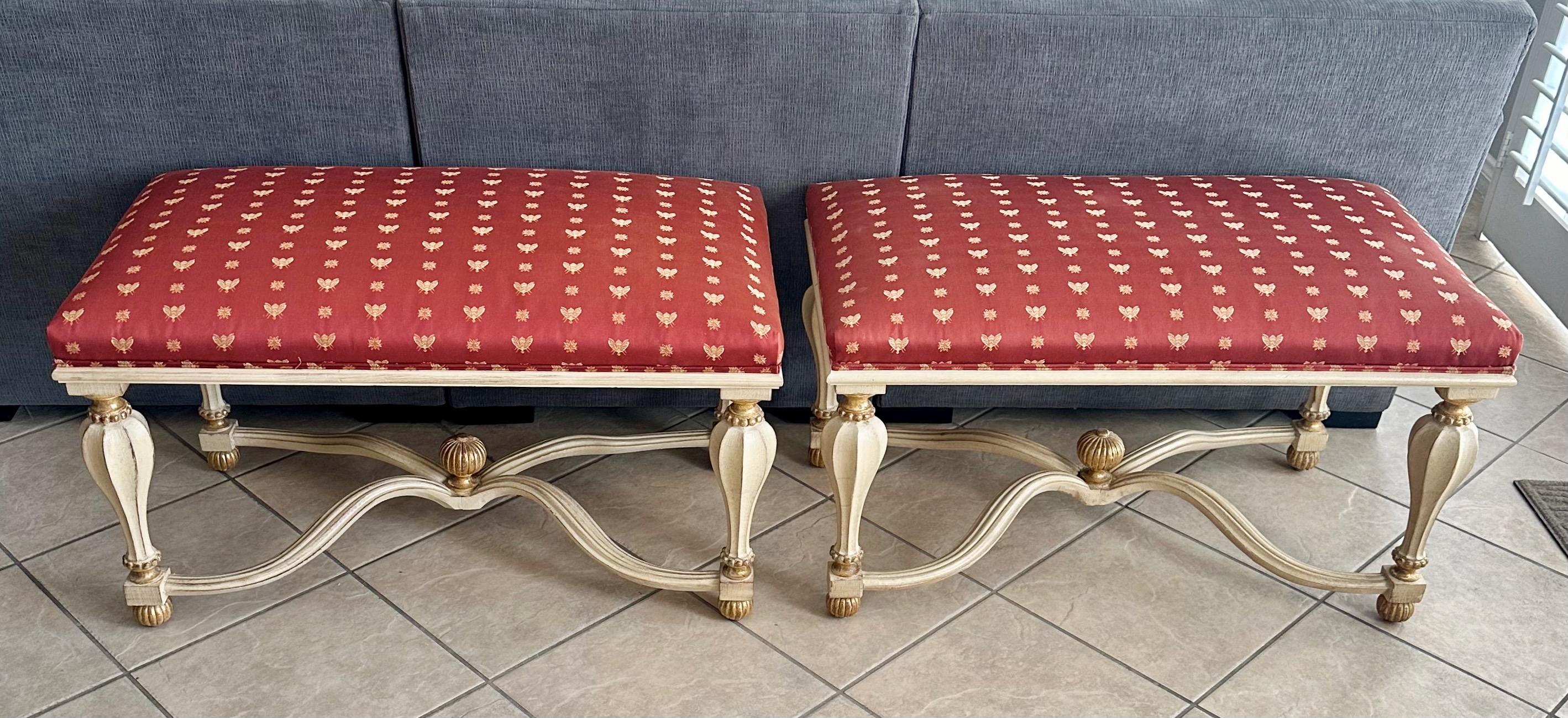 Pair of larger scale Italian wood carved rectangle shaped benches, painted in a creamy white with gold leaf accents. The benches are supported with a waving 