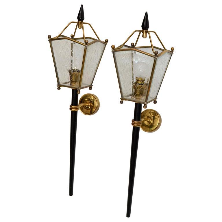 Coppia di appliques, appliques e lanterne in stile Jacques Adnet, in ottone, vetro acidato e metallo color canna di fucile.
In perfette condizioni di funzionamento, ogni applique è dotata di 1 lampadina da 40 watt al massimo. 40 watt o lampadina