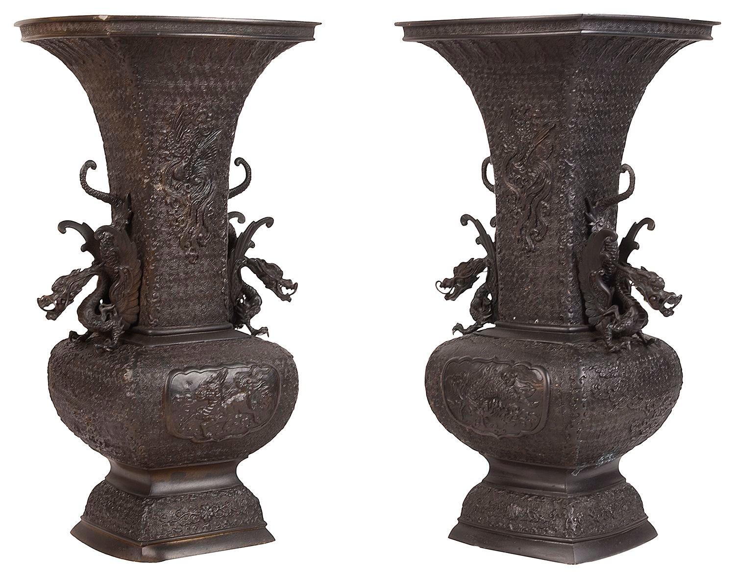Très belle paire de vases / lampes en bronze de la fin du 19e siècle de la période japonaise Meiji (1868-1912). Magnifique décor classique en relief avec des panneaux insérés représentant des créatures mythiques et des poignées de dragon, signé à la