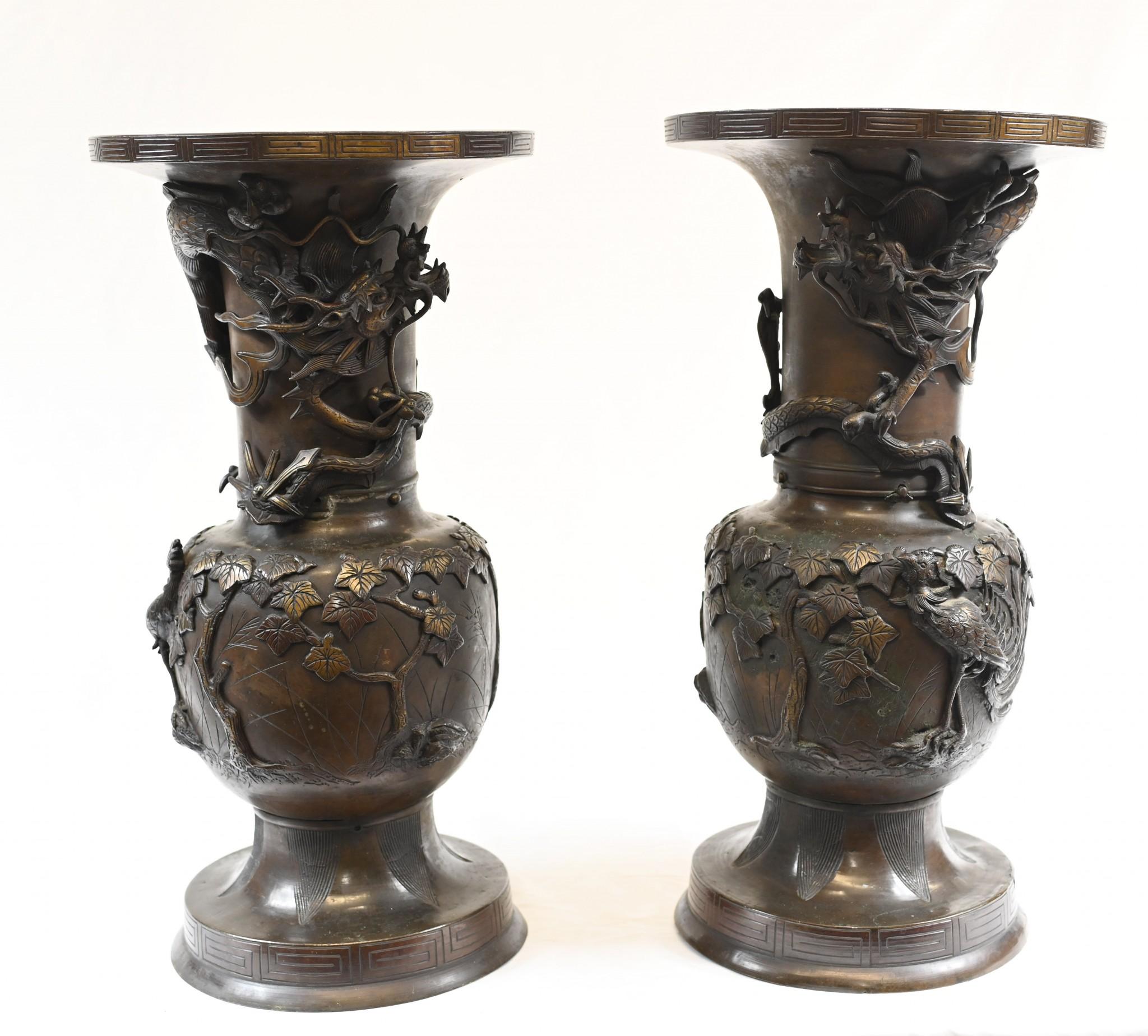 Pair of Japanese bronze vases highly decorated with leaves and plants
Decorated with amazing dragons in relief around the urn
Also features foliage and birds
Circa 1880 
Some of our items are in storage so please check ahead of a viewing to see