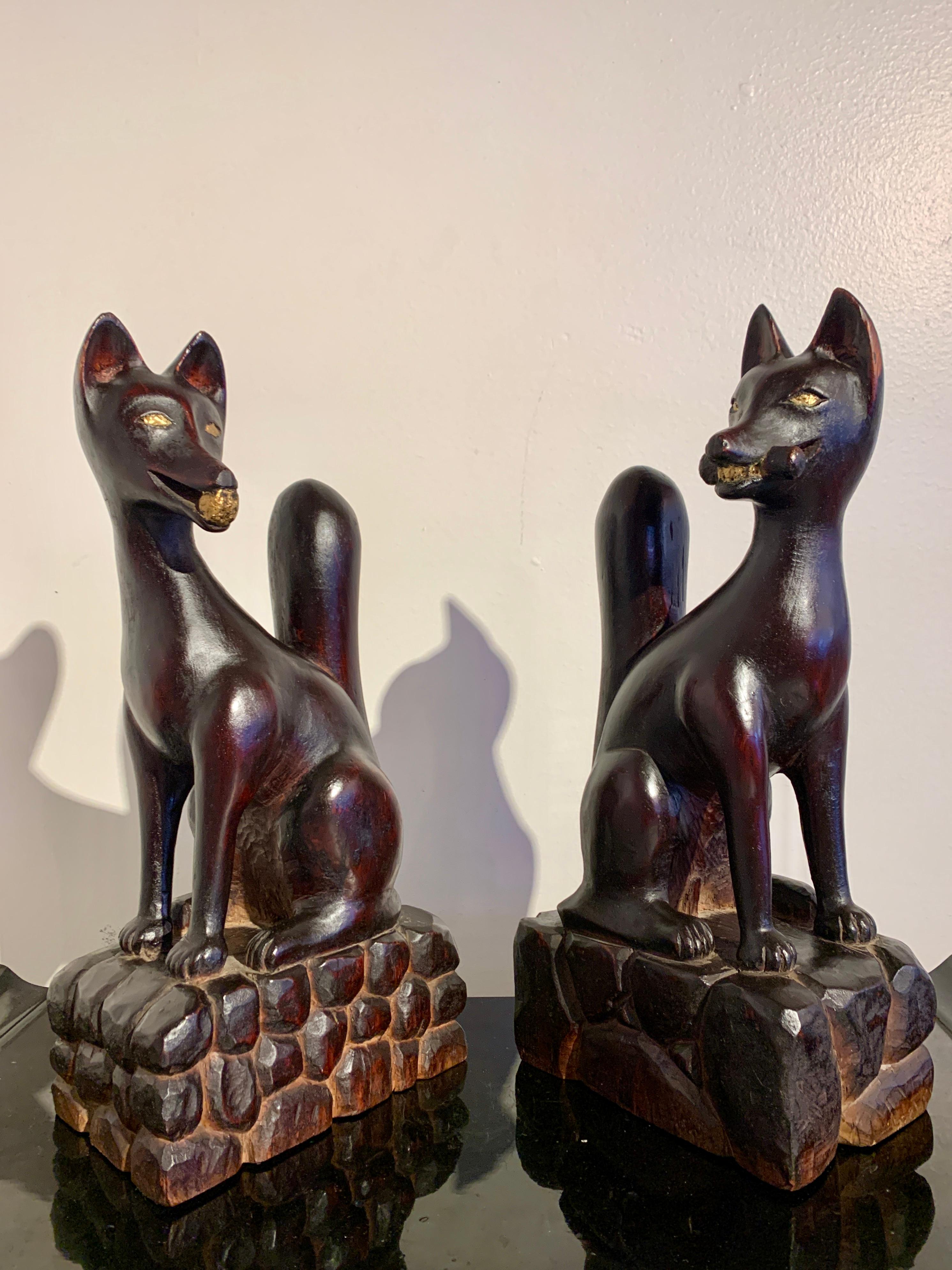 A delightful and mischievous pair of Japanese carved and lacquered wood Inari foxes, kitsune, dated Showa year twenty six, corresponding to 1951, Japan.

The foxes are carved from a single block of keyaki (elm) wood, and lacquered with polychrome