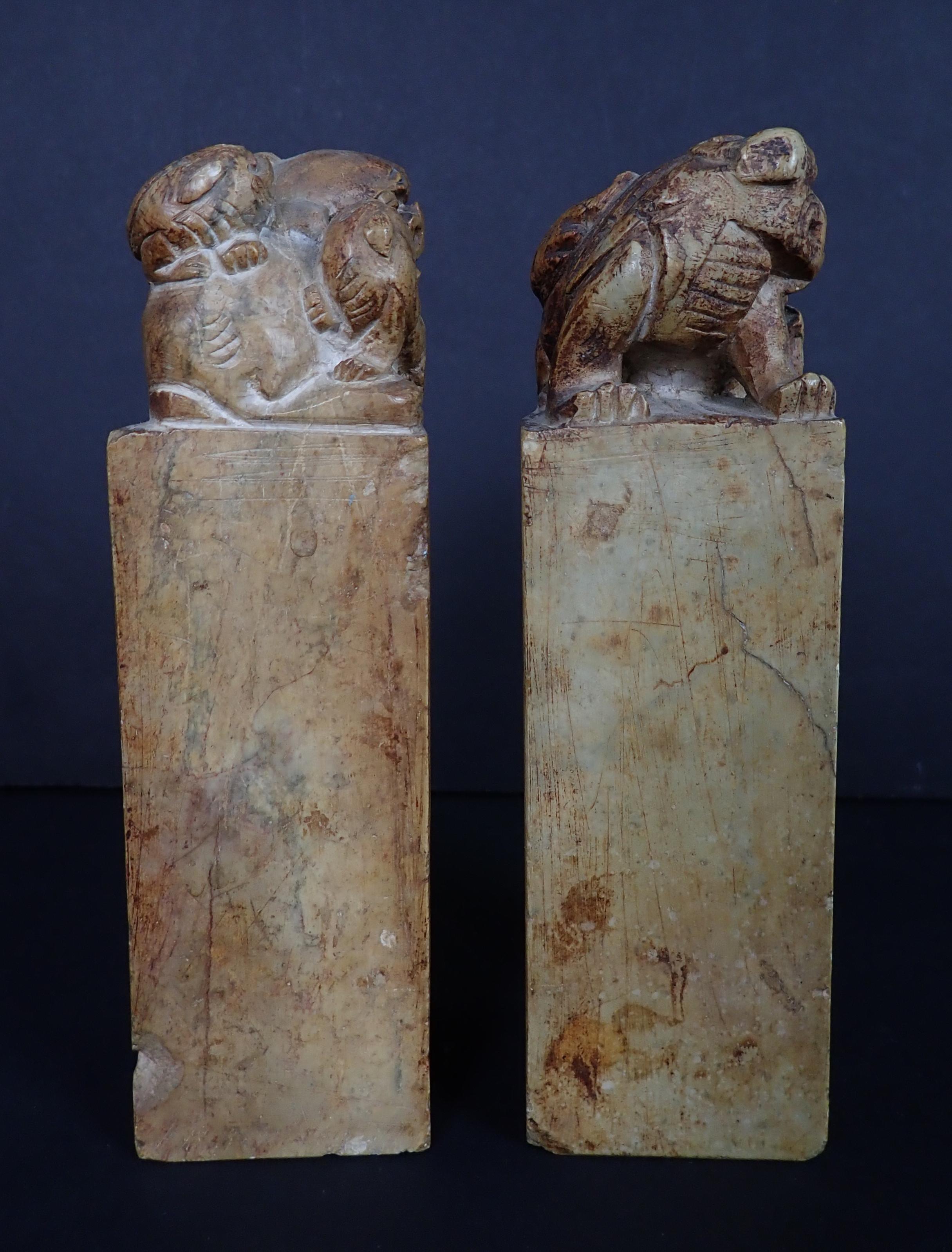 Pair of hard stone chop seals decorated with foo dogs. Two lines of calligraphy across the front. Incised seal on the bottoms.
  