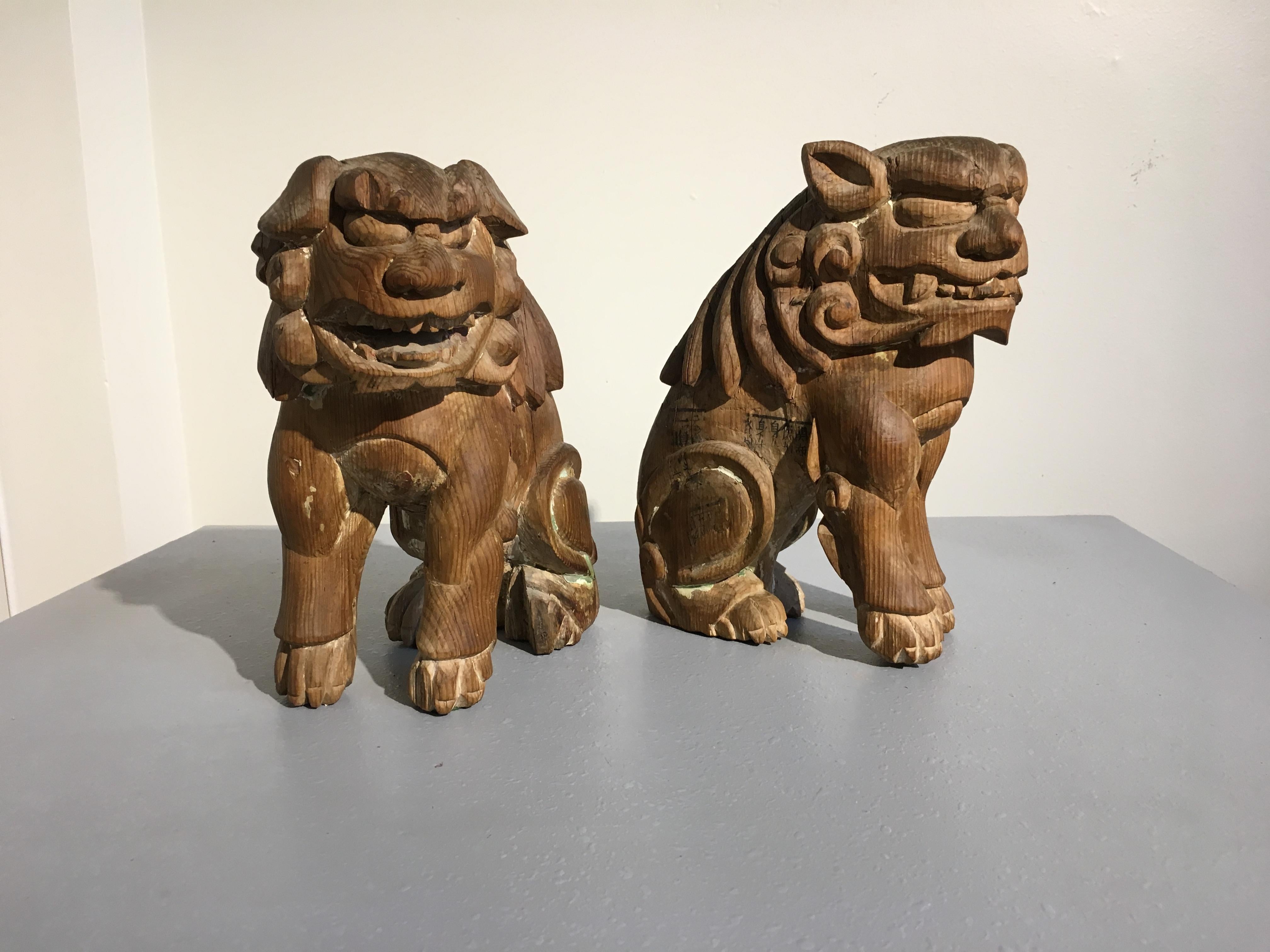A charmingly grotesque pair of Japanese mingei (folk) carved guardian lions, komainu, Edo Period, early 19th century. 

Each carved from a single block of hinoki (Japanese cypress) wood. They are portrayed seated on their haunches, hunched, as if
