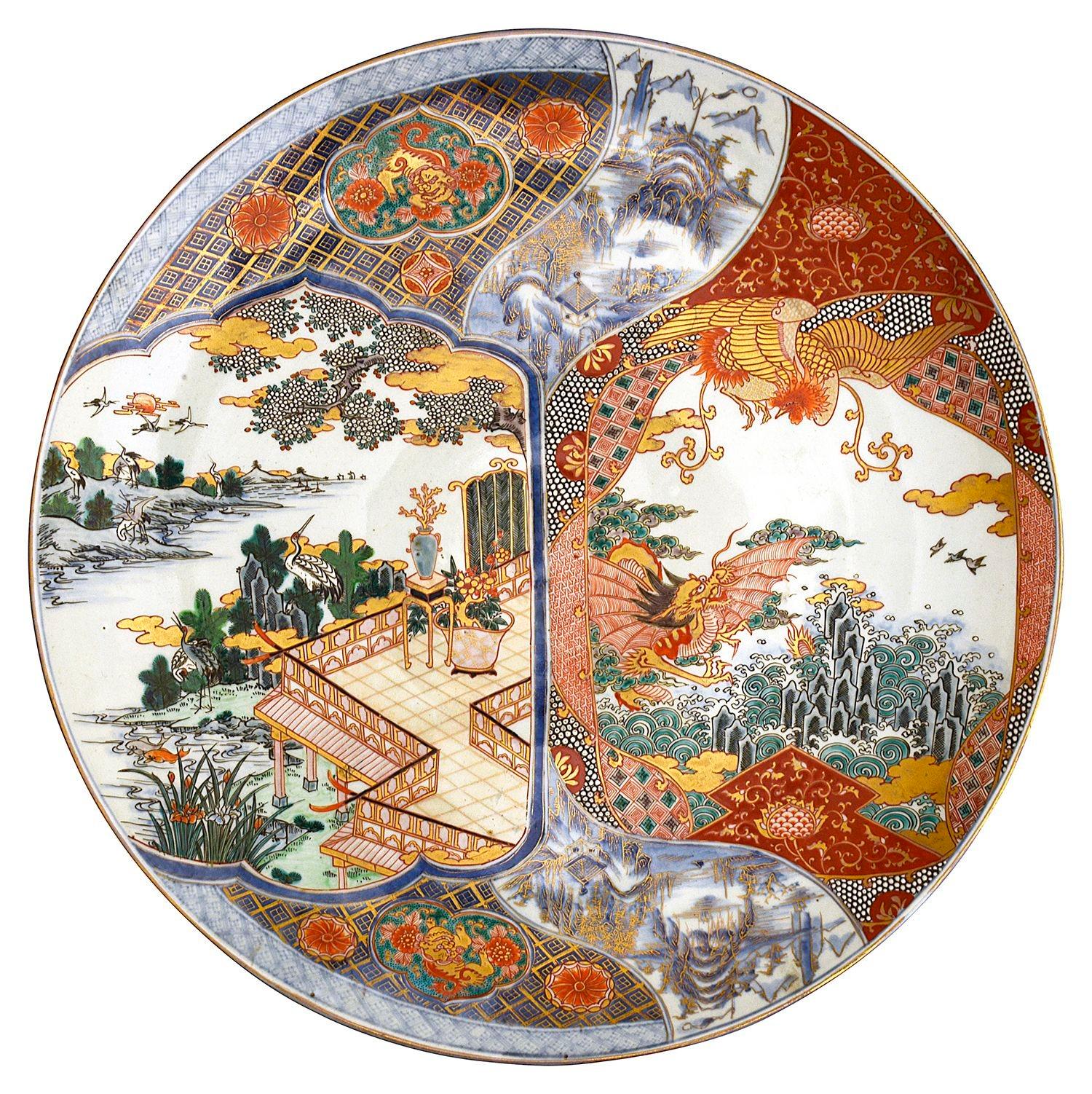 Pareja muy decorativa e impresionante de cargadores de porcelana japonesa Imari de gran calidad. Cada una con decoración de motivos clásicos, escenas que representan edificios pagoda con terrazas que contemplan escenas montañosas y lagos. también