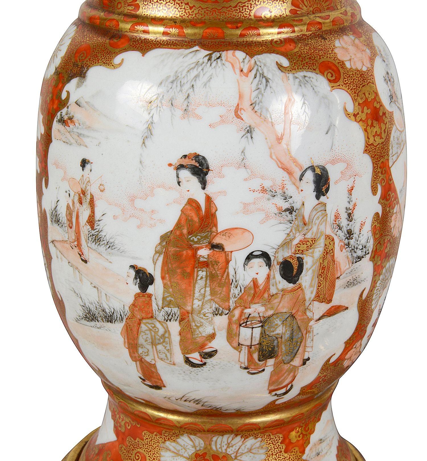 Paire de lampes en porcelaine japonaise Kutani de la fin du XIXe siècle. Chacune d'entre elles présente un fond orange classique avec une décoration dorée à enroulement classique. L'encastrement comporte des panneaux peints représentant des geishas
