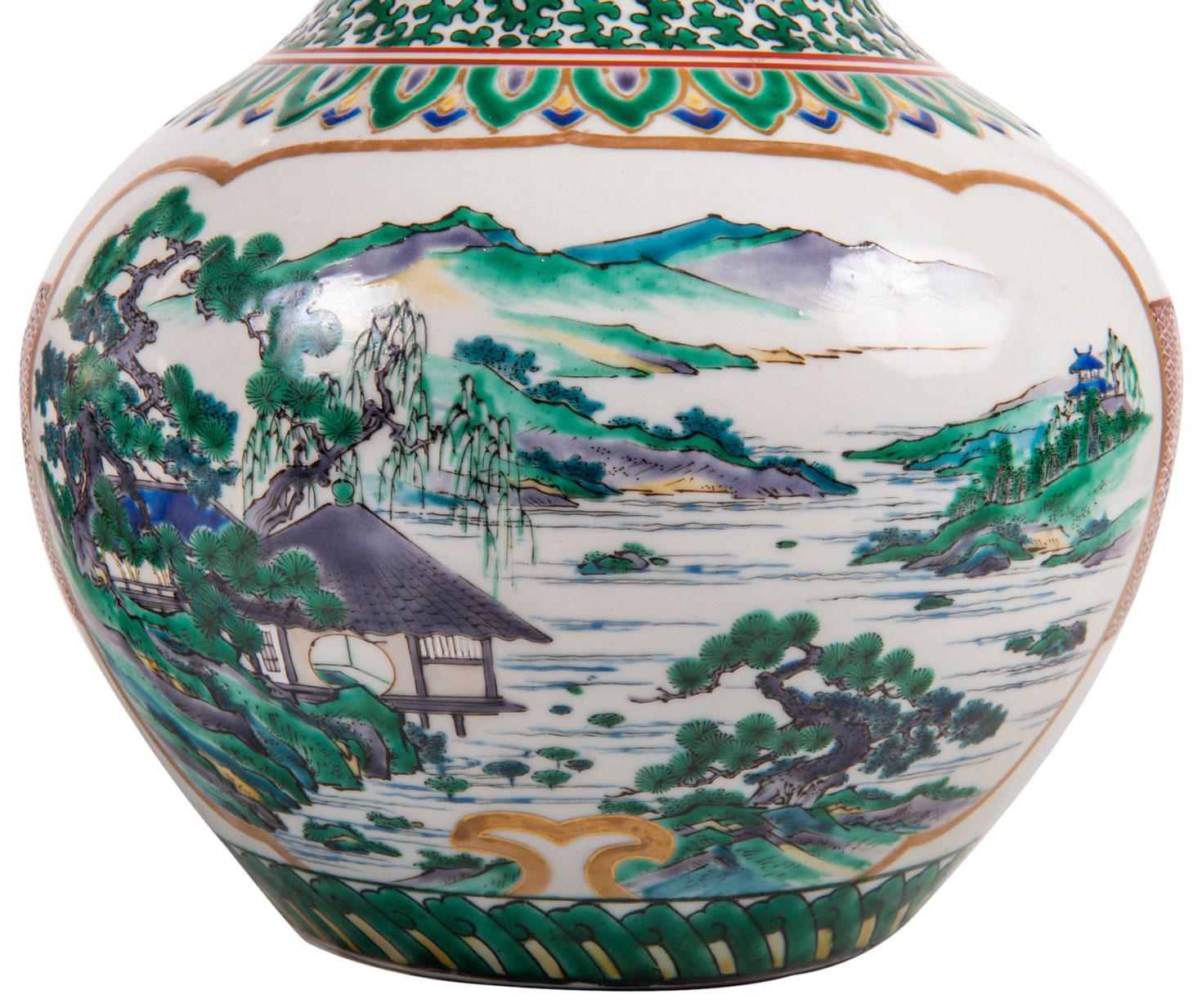 A good quality pair of late 19th century Japanese Kutani porcelain vases, each having green ground and gold motif decoration, inset panels depicting lake and mountainous scenes.
