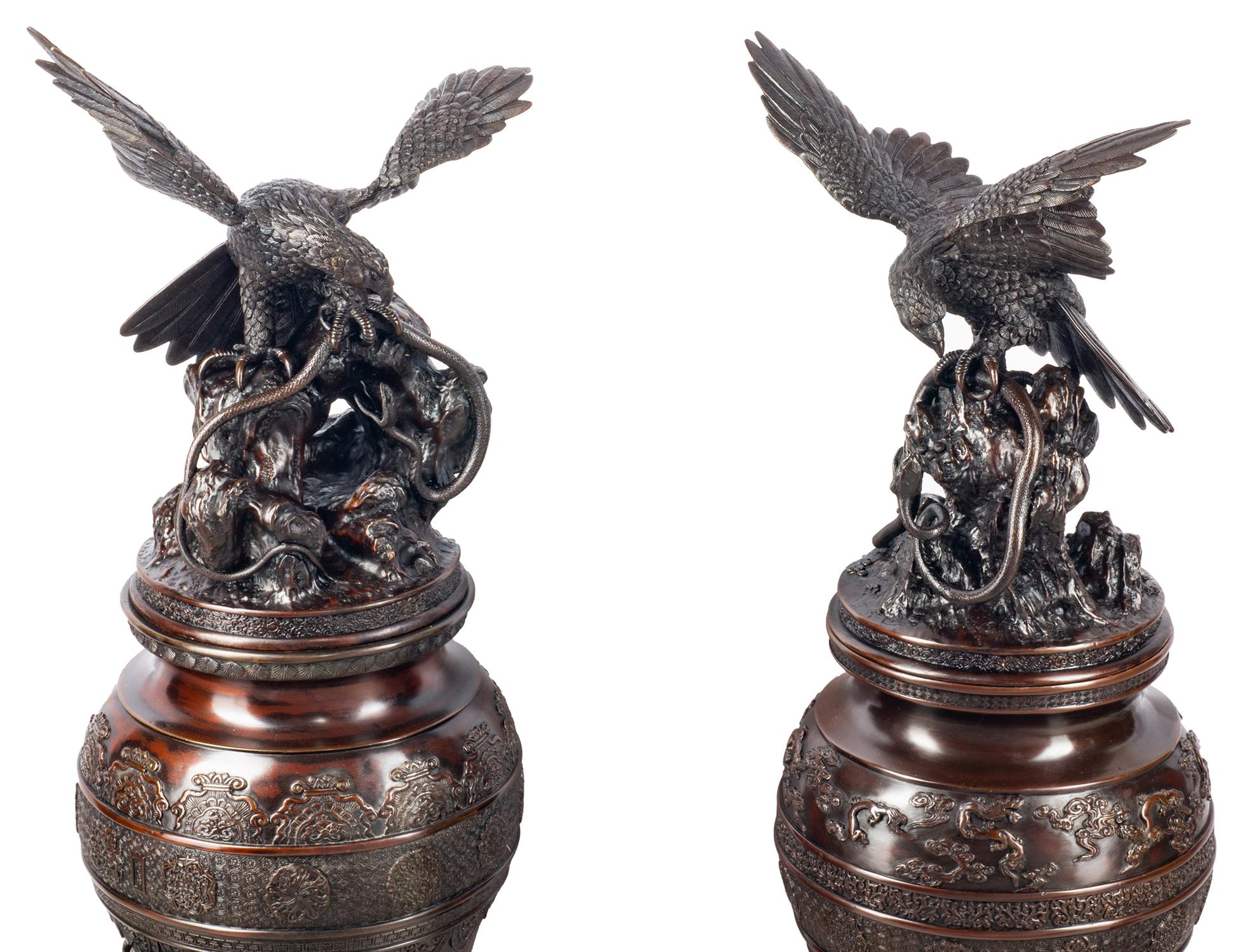 A spectacular pair of Japanese Meiji period (1868-1912) Bronze Koros, each lid having eagles hunting snakes on a rocky outcrop. The vases having classical Japanese motif decoration around, and supported two jovial priest like figures either side of