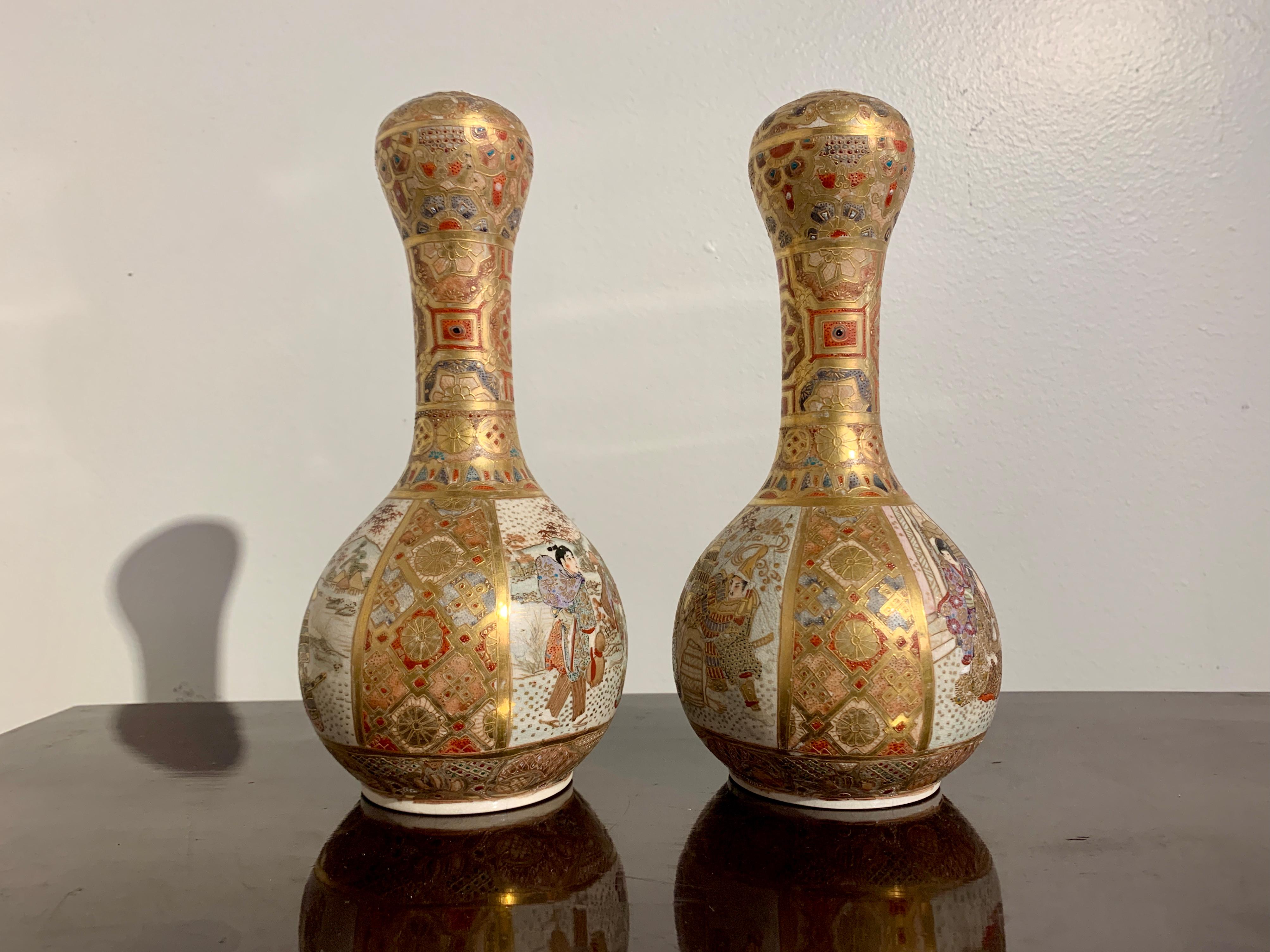A finely decorated pair of Japanese Satsuma vases with garlic head mouths, Meiji period, early 20th century, Japan.

The pair of Satsuma vases richly decorated with sumptuous gilding and colorful raised enamels. The bodies of globular form with a