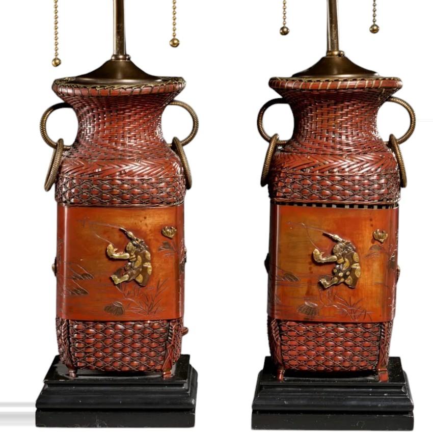 Pair Japanese Copper Shakudo lamps in red woven copper with brass ribbon and mixed metal panels depicting floral and figural fisherman motifs. 

Meiji Period (Late 19th c.)

rewired as lamps

23.5