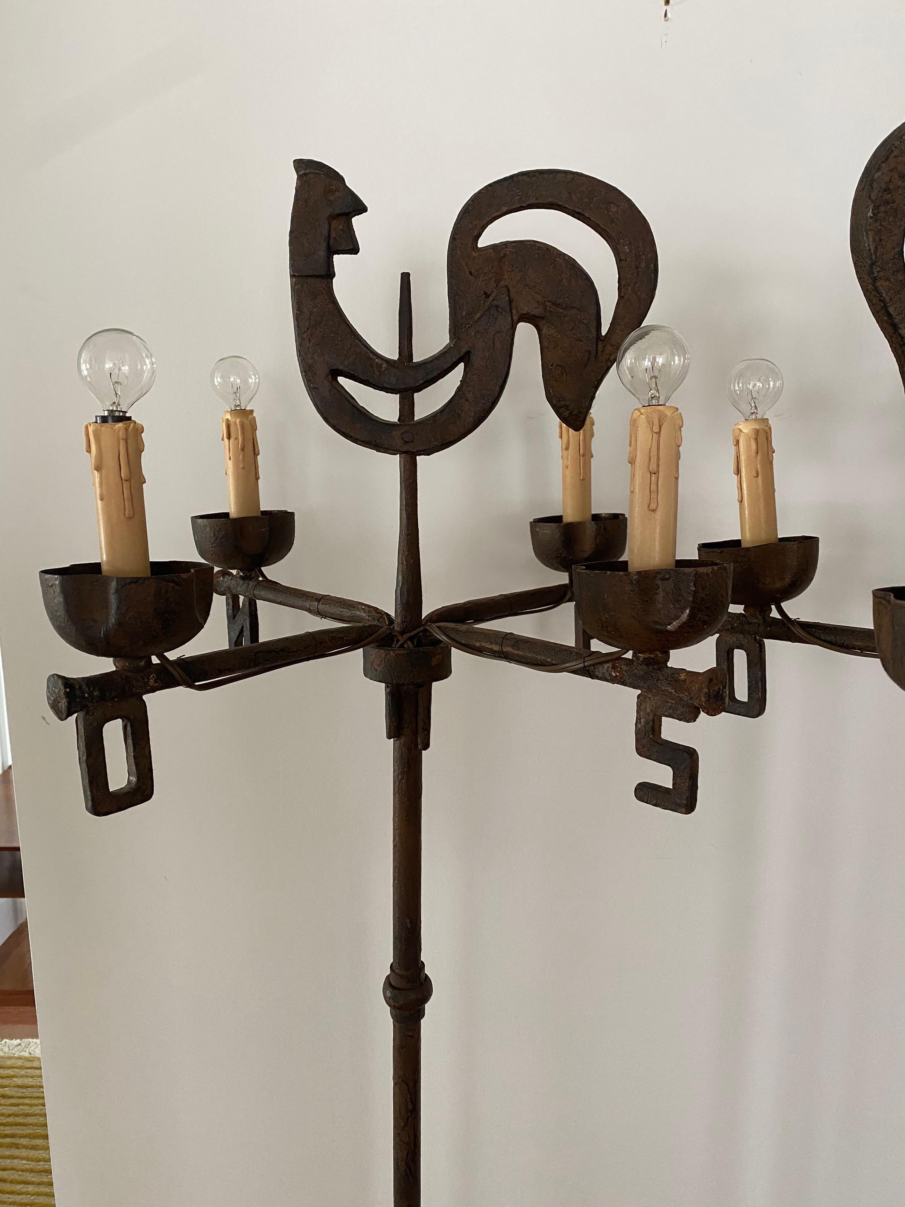 Pair of handcrafted pair of cast and wrought iron by Ateliers de Marolles under the direction of Jean Touret. The studio in South France designed and crafted lighting and furniture during the 1950s.

This pair has a rooster weather vane motifs and