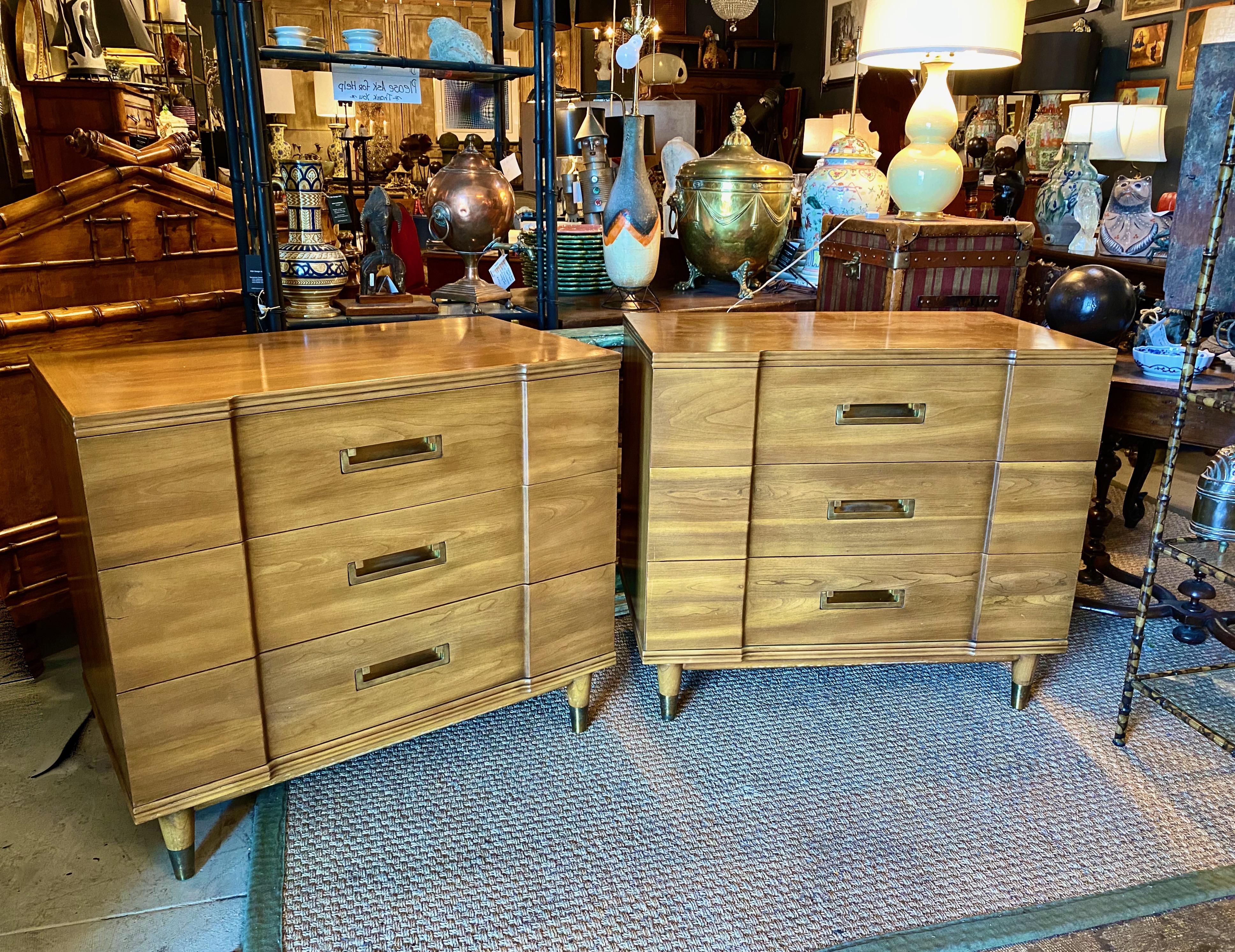 This a superb pair of c. 1955-1960 John Widdicomb chests of drawers in finely grained and figured claro walnut. The breakfront form of the chests is unusual and a mark of design quality. The sculptural brass hardware has been buffed and is in