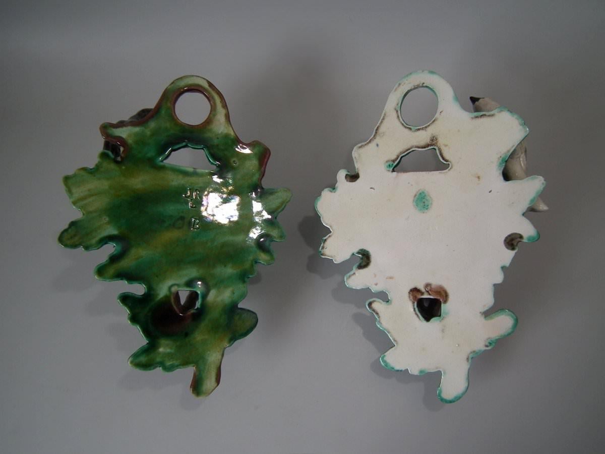 Pair of J.R.L. Majolica wall pockets which feature a bird perched on a branch above a woven nest. Colouration: green, brown, ochre, are predominant. The piece bears maker's marks for the J.R.L. pottery.