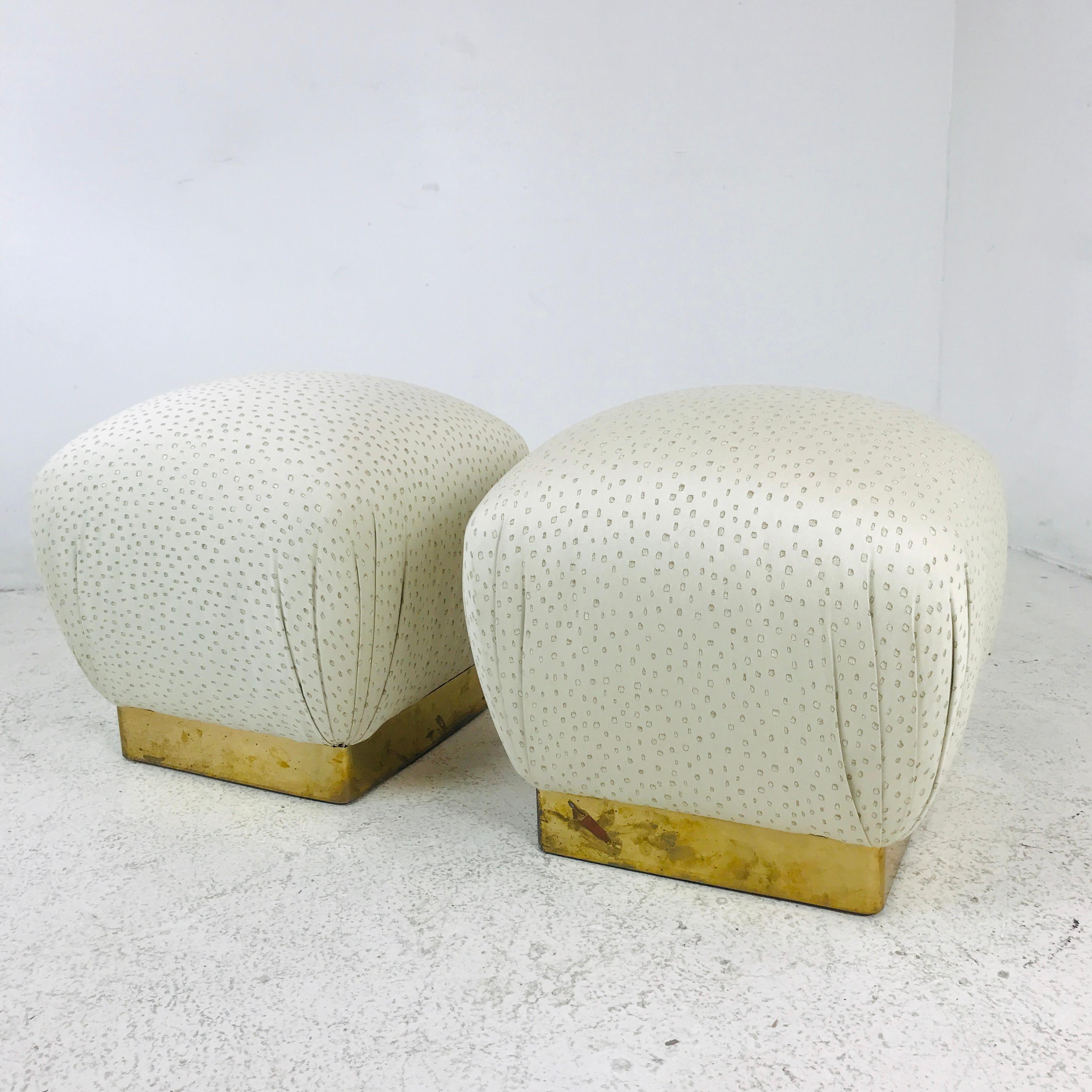 Fantastic pair of vintage Karl Springer style poufs. Features brass plinth bases and great upholstery. Some wear/patina on brass. Perfect as stools, benches, or ottomans.