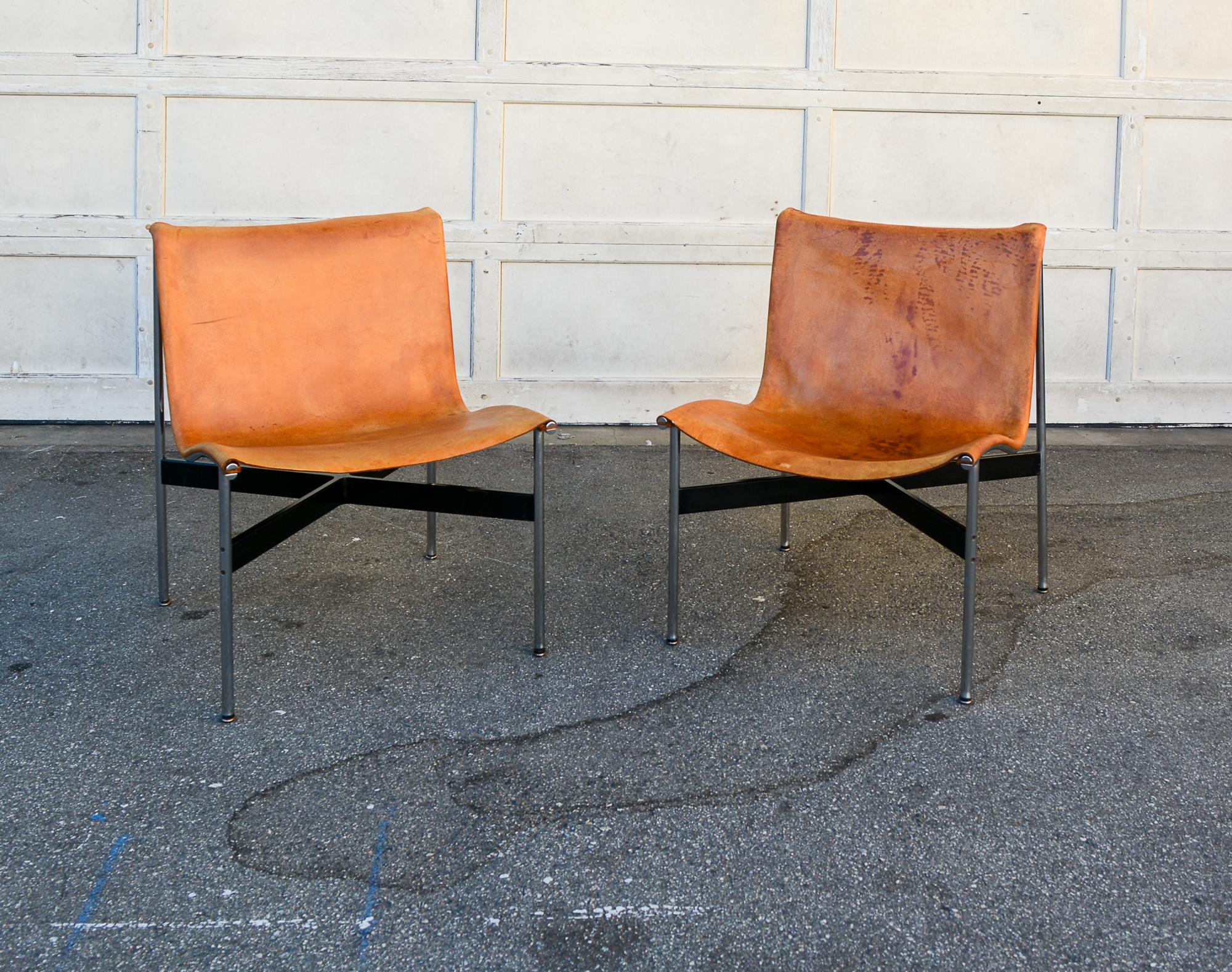 Pair of New York lounge chairs designed by William Katavolos, Ross Littell and Douglas Kelley for Laverne Originals. These have the original leather slings. The leather has some darkened areas and small stains. There is some crazing to the leather