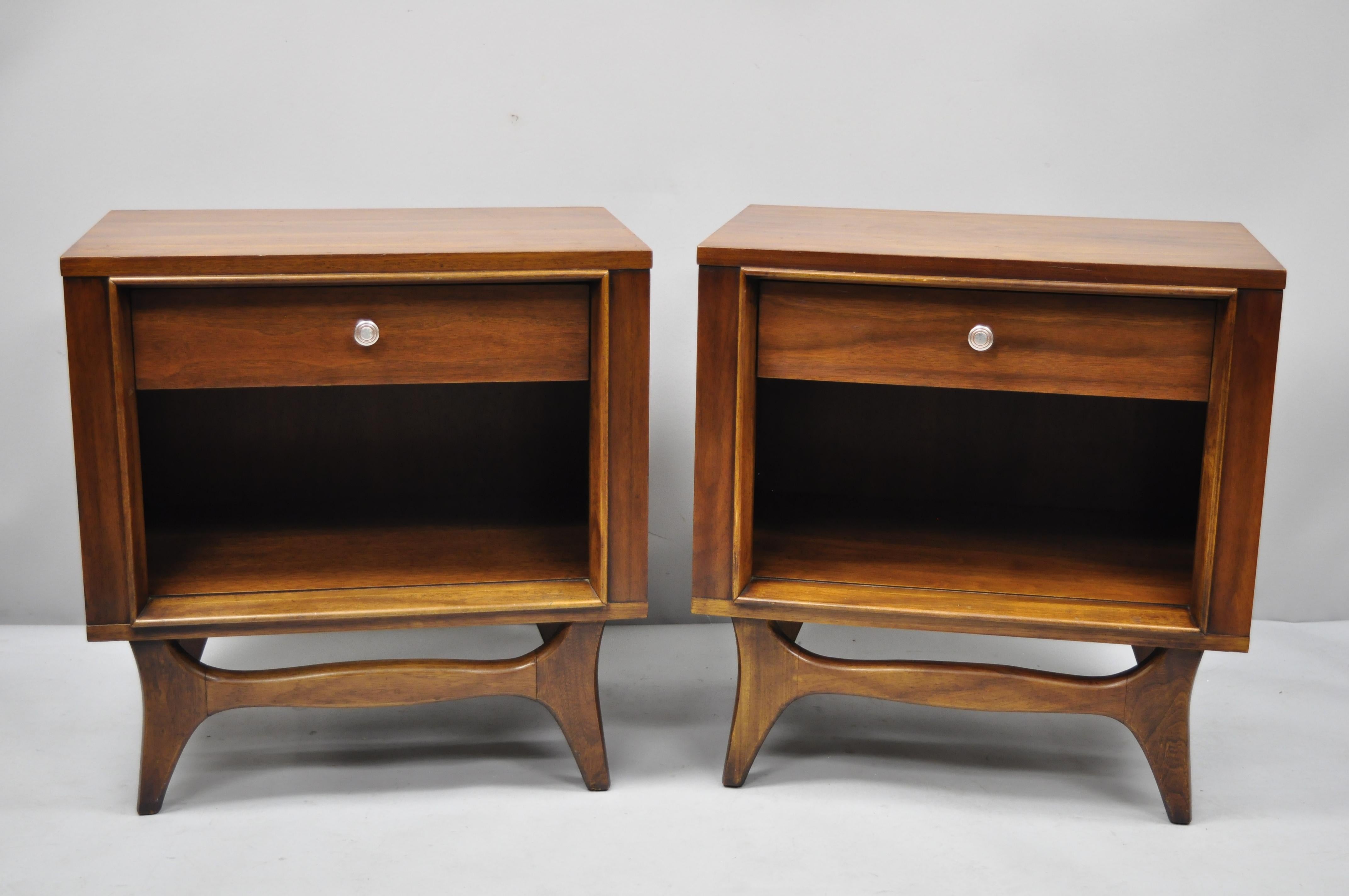 Pair of Kent Coffey insignia walnut Mid-Century Modern nightstands. Item features beautiful wood grain, tapered legs, circa 1960s. Measurements: 25