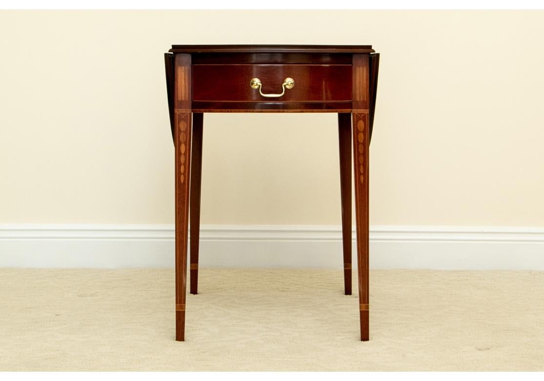 A pair of elegantly constructed Pembroke Tables with very fine form and color. Drop leaf side tables with linear and leafy satinwood inlaid legs, bow front ends and frieze drawer. Raised on square tapering legs. 
Dimensions:
With leafs down - 31