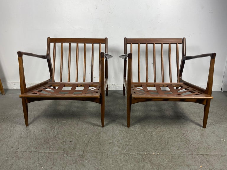 Classic pair Modernist Lounge Chairs designed by Kofod Larsen for Selig..Beautiful sculpted walnut frames.. Superior quality and construction.. in need of seat and back cushions.. Hand delivery avail to New York City or anywhere en route from