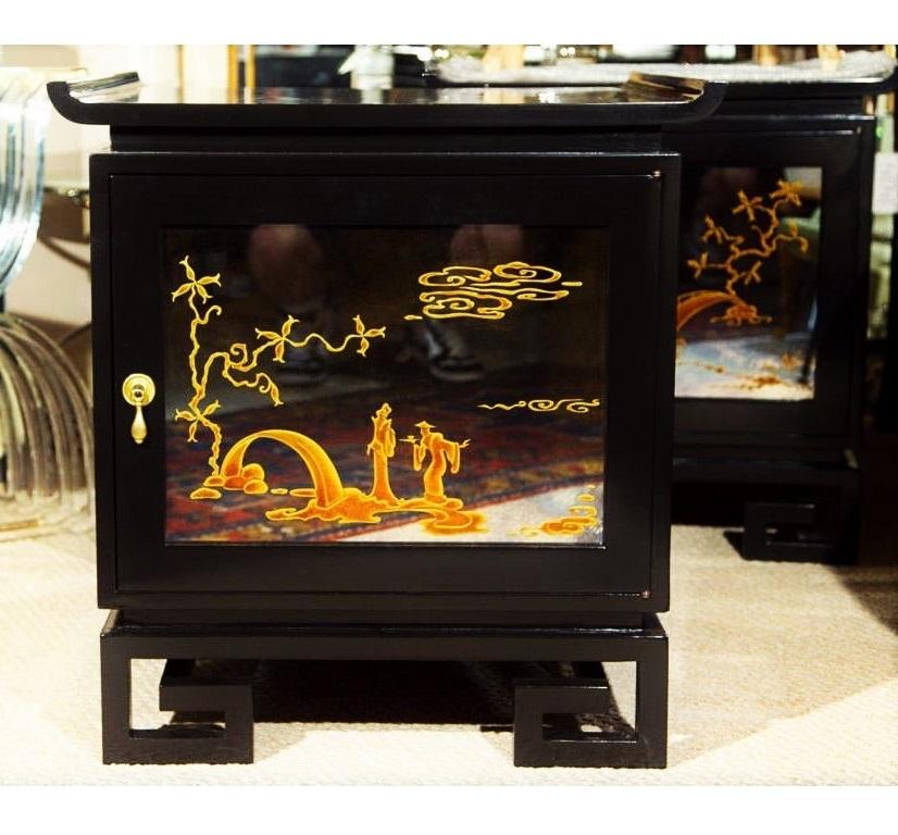 Pair of end tables or nightstands designed by James Mont. Freshly lacquered cabinets in black, featuring a Ming style pagoda top, front doors adorned with églomisé mirror panels depicting chinoiserie scene on plinth legs with Greek key design. Doors