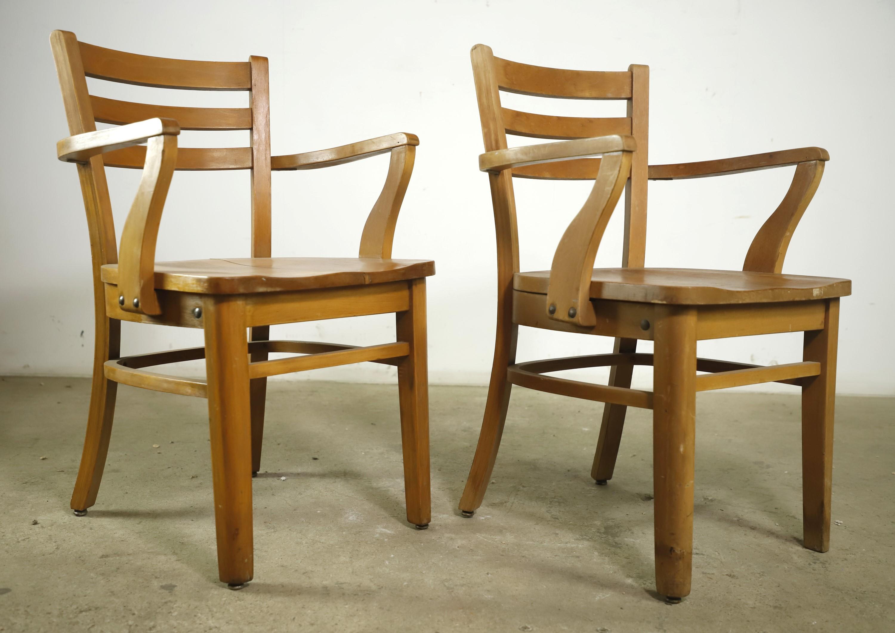 Early 20th century solid maple arm chairs made in a ladderback style. Manufactured by the National Store Fixture Co., Odenton, MD. The National Store Fixture Company was a woodworking business in Baltimore prior to 1941. Priced as a pair. Please