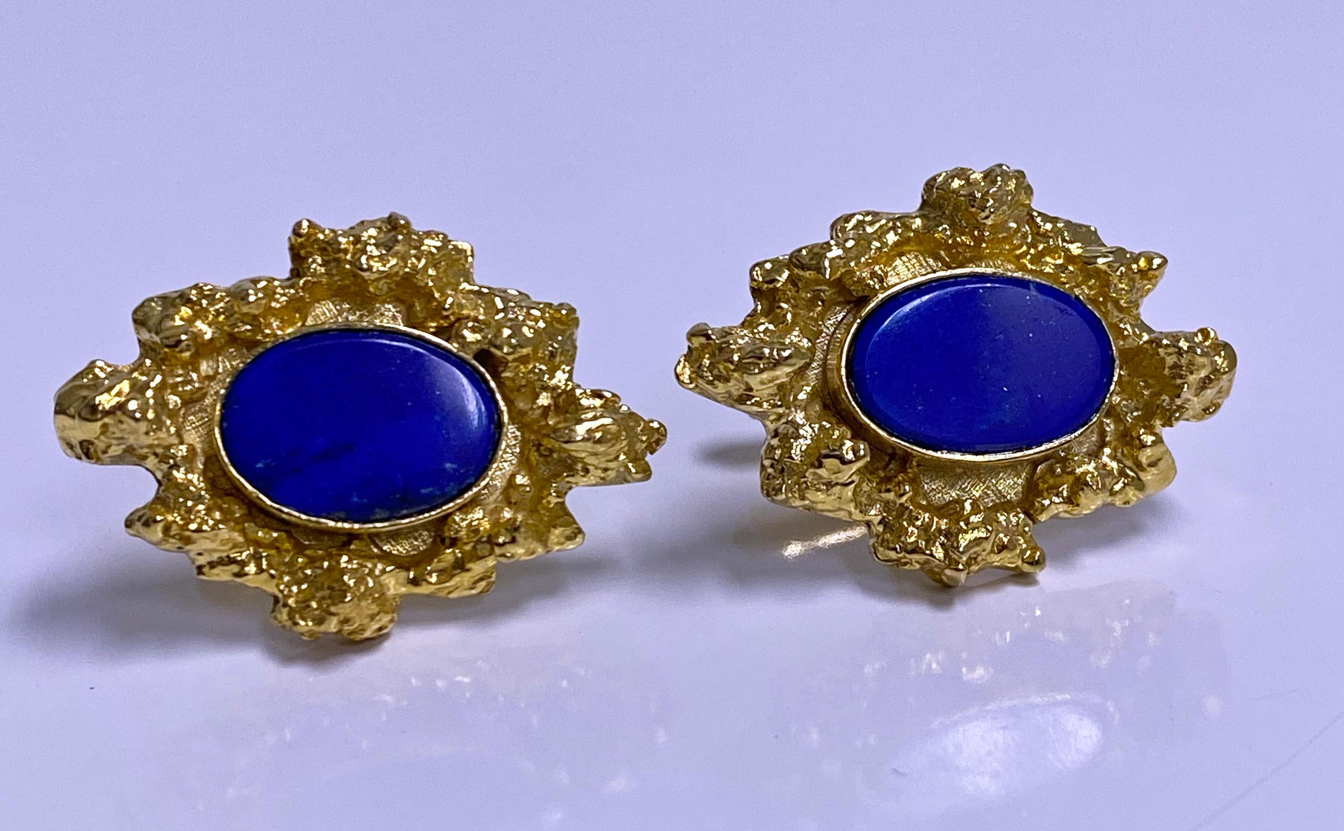Pair Lapis 14K gold cufflinks C.1970. Each of custom abstract nugget form design mount, bezel set with blue oval tablet cut lapis lazuli, torpedo tubular hinged fitments. Each front measures approximately 30 x 22mm. Lapis measures 12.70 x 9.50 mm.