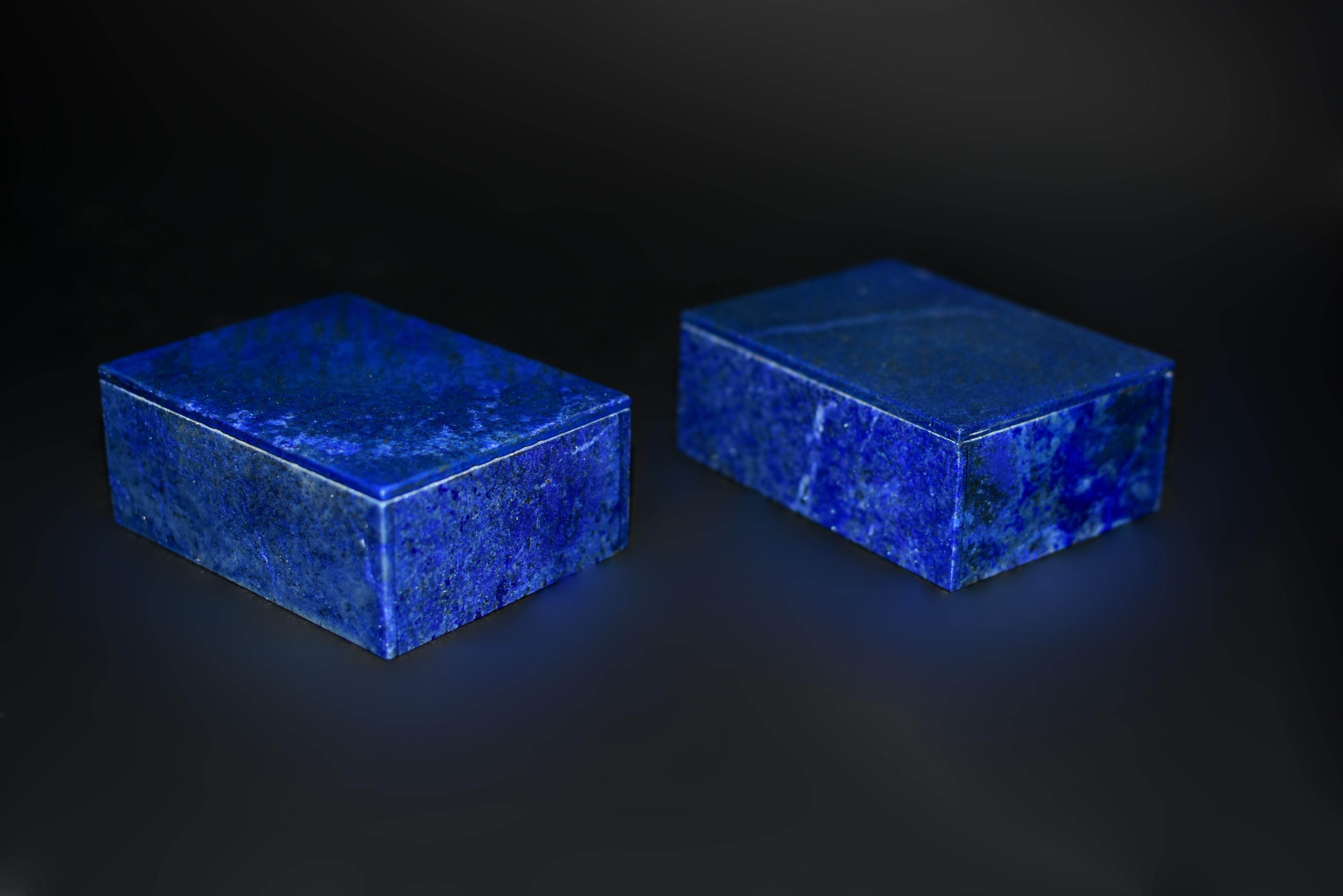 A pair of fine lapis lazuli boxes sourced from the depths of Afghanistan, each exuding an aura of regal splendor with saturated royal blue hue. The beautiful natural inclusions of gold and white, reminiscent of a celestial tapestry of golden shower