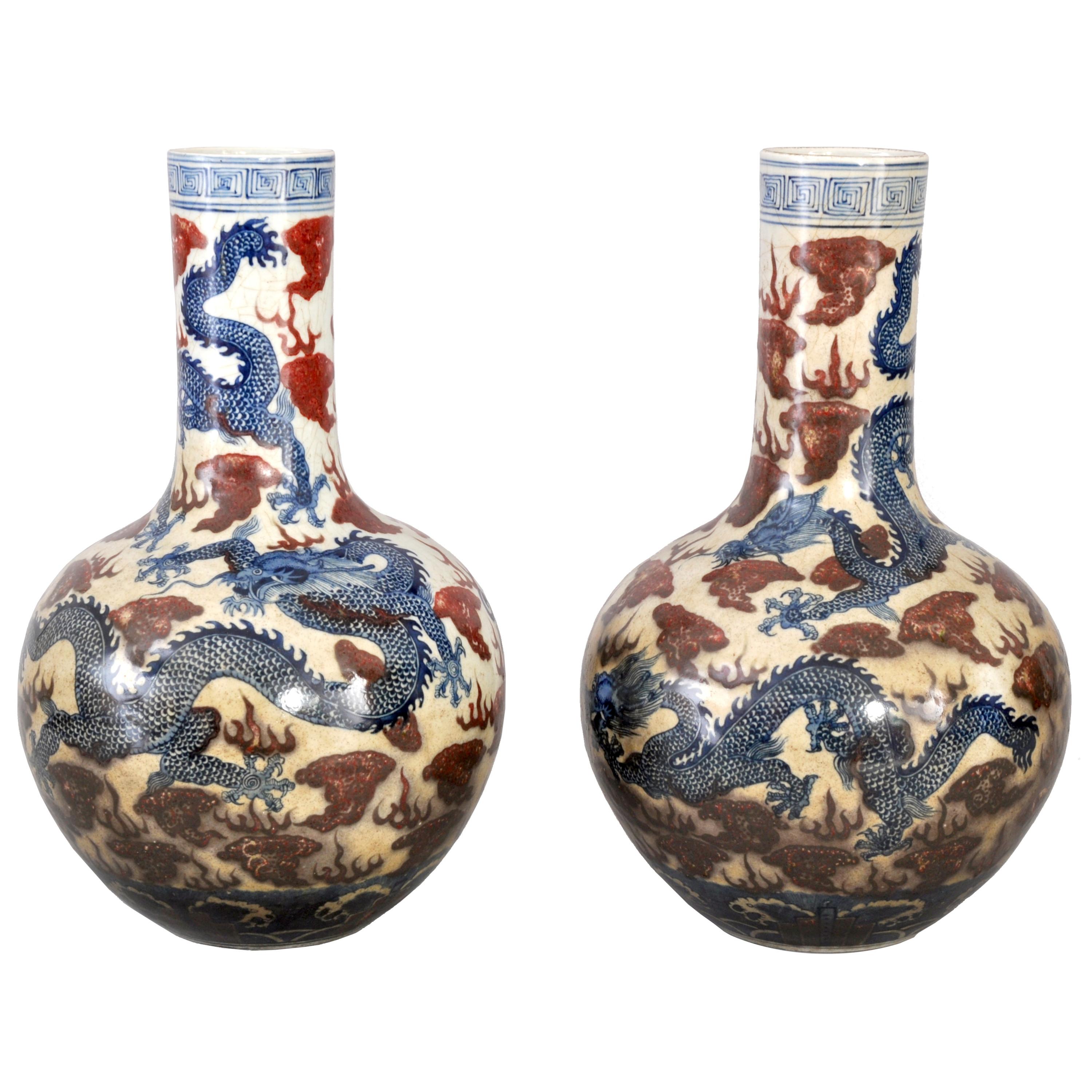A good pair of large antique Chinese Qing dynasty blue and white dragon vases, circa 1880. Each vase of globular, bottle shaped form and hand painted with blue and red underglaze decoration, the vases are decorated with Imperial five toed dragons in