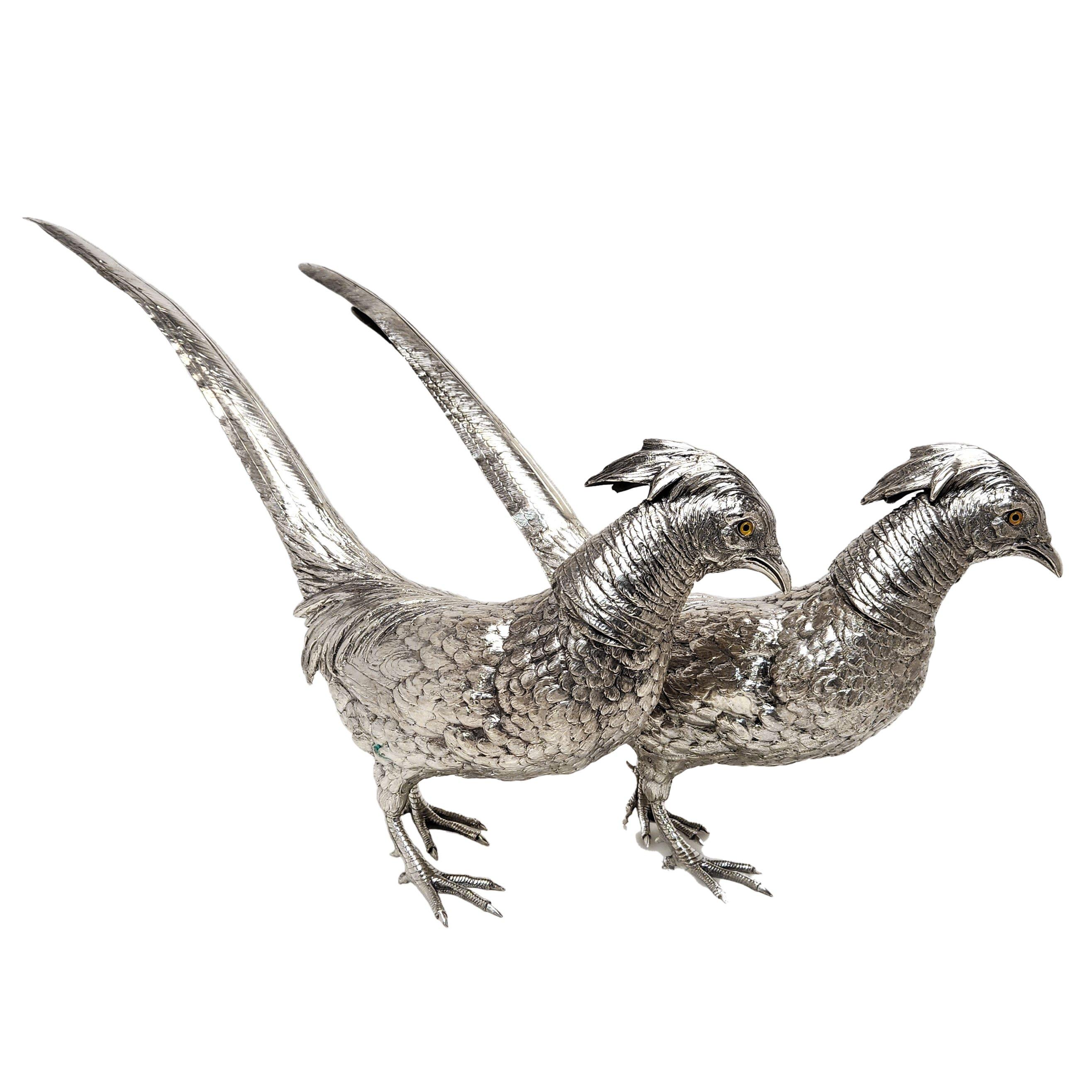 Una grande e imponente coppia di fagiani d'argento antichi. Questi modellini di fagiani sono curati nei minimi dettagli e presentano occhi di vetro incastonati. Gli Uccelli hanno teste rimovibili come le loro controparti storiche.

Realizzato in