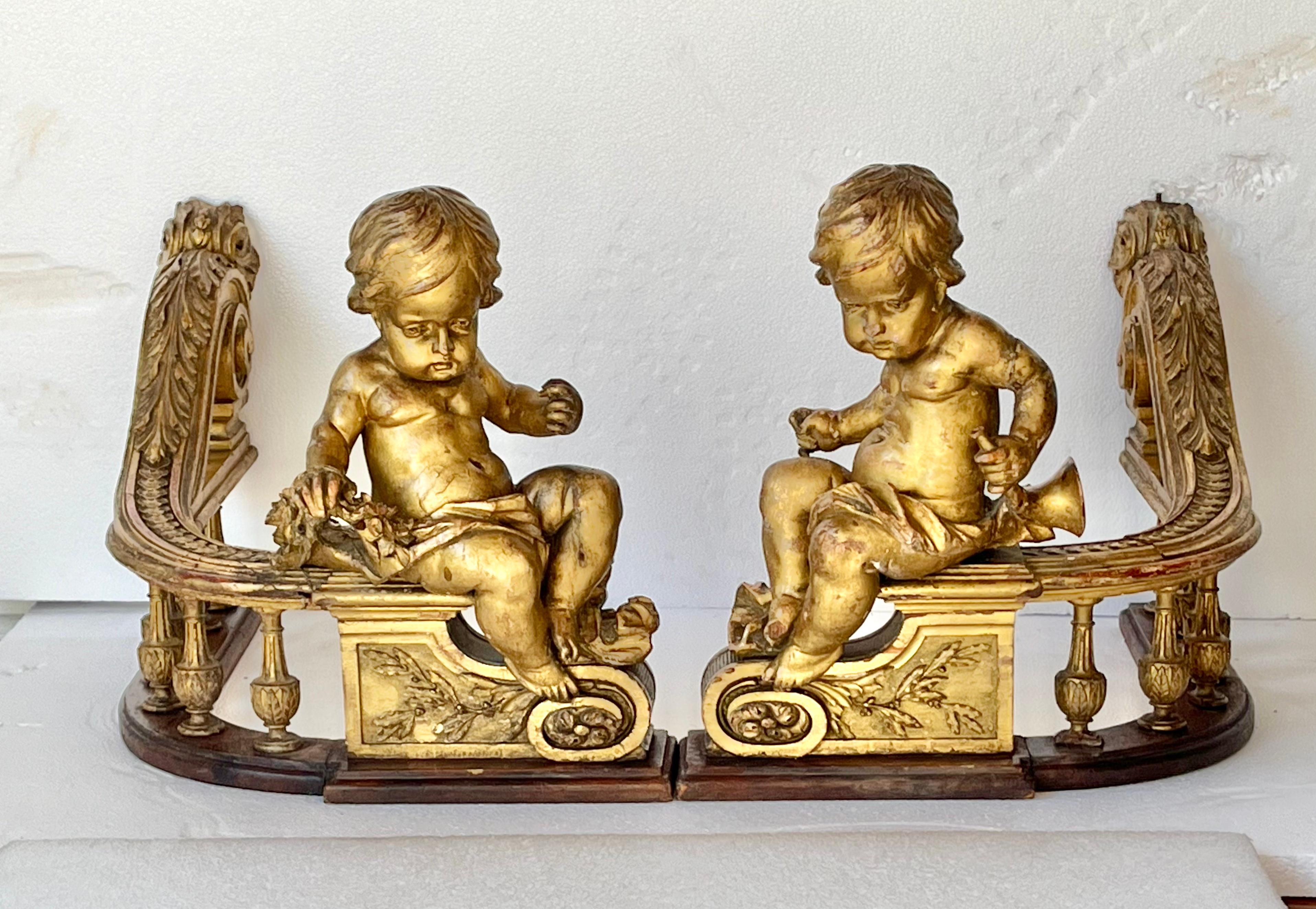 Pair or set of giltwood fragments possibly to a larger ensemble , possibly for a table or chest . Each cherub or putti carved of wood uniquely  in styled poses , both with carved draping , one with carved floral garland . 

Appears to be of secular