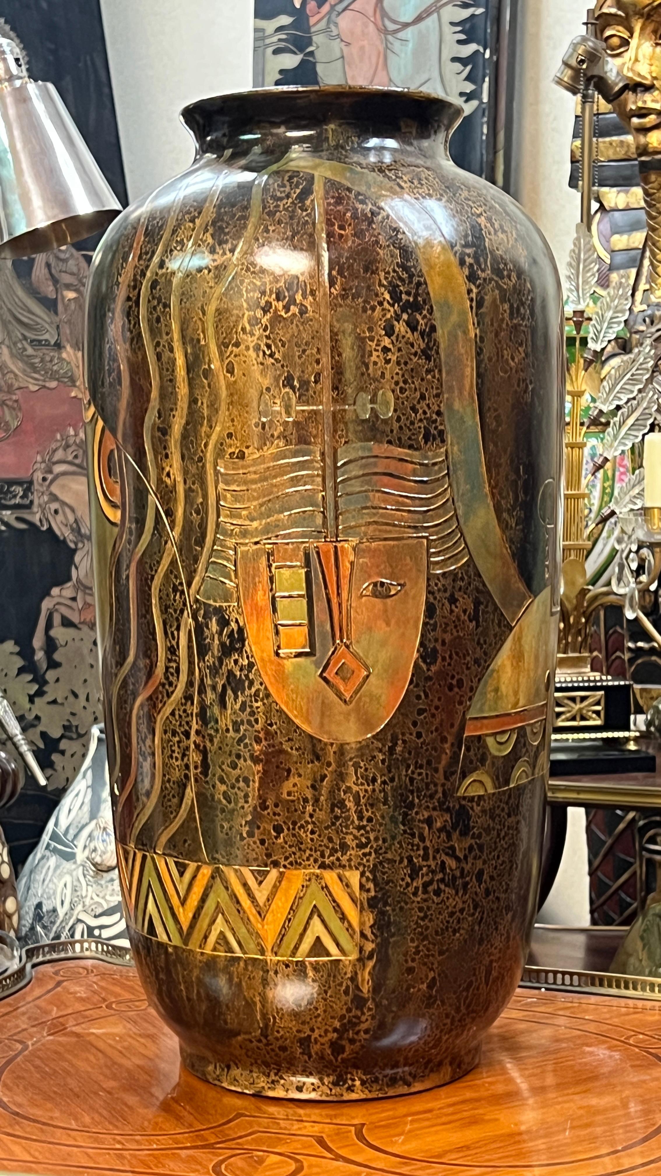 Pair of vintage, mid-century modern vases in the Art Deco style with mottled enameled finishes and incised stylized designs including masks, geometric motifs and floral bouquets.  