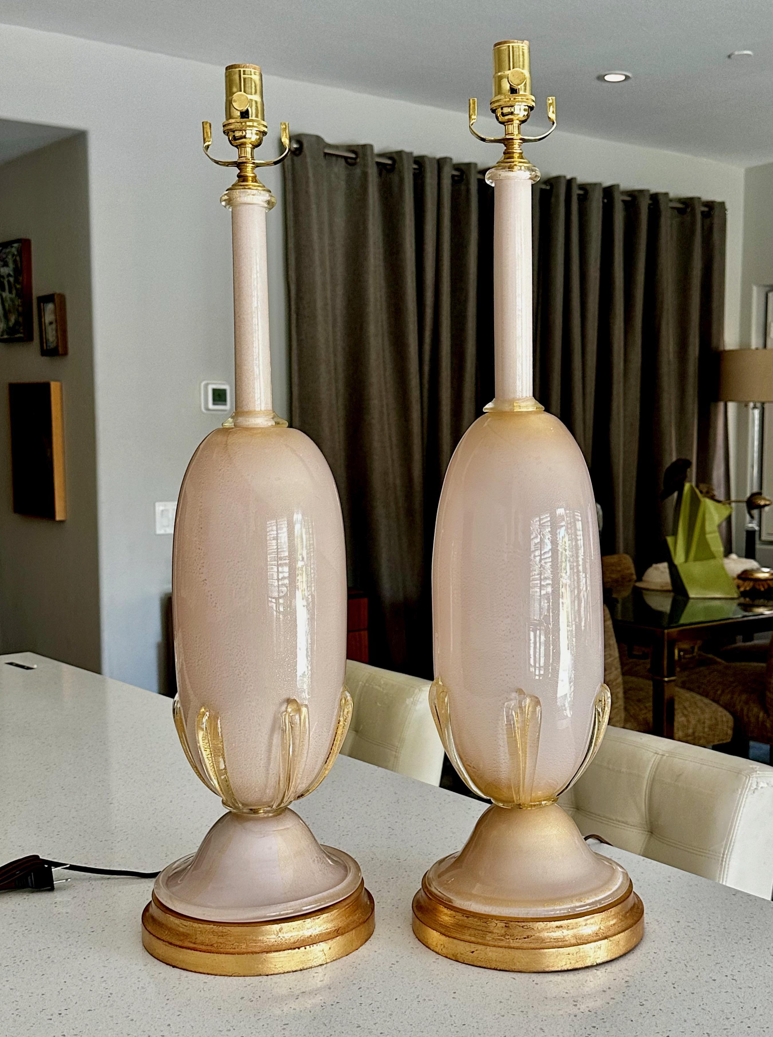 Pair large scale Murano Italian hand blown pink or salmon glass table lamps with gold inclusions. The hand blown glass bodies rest on giltwood bases. Attributed to Barovier & Toso. Rewired with new three-way brass sockets and cords. Overall height
