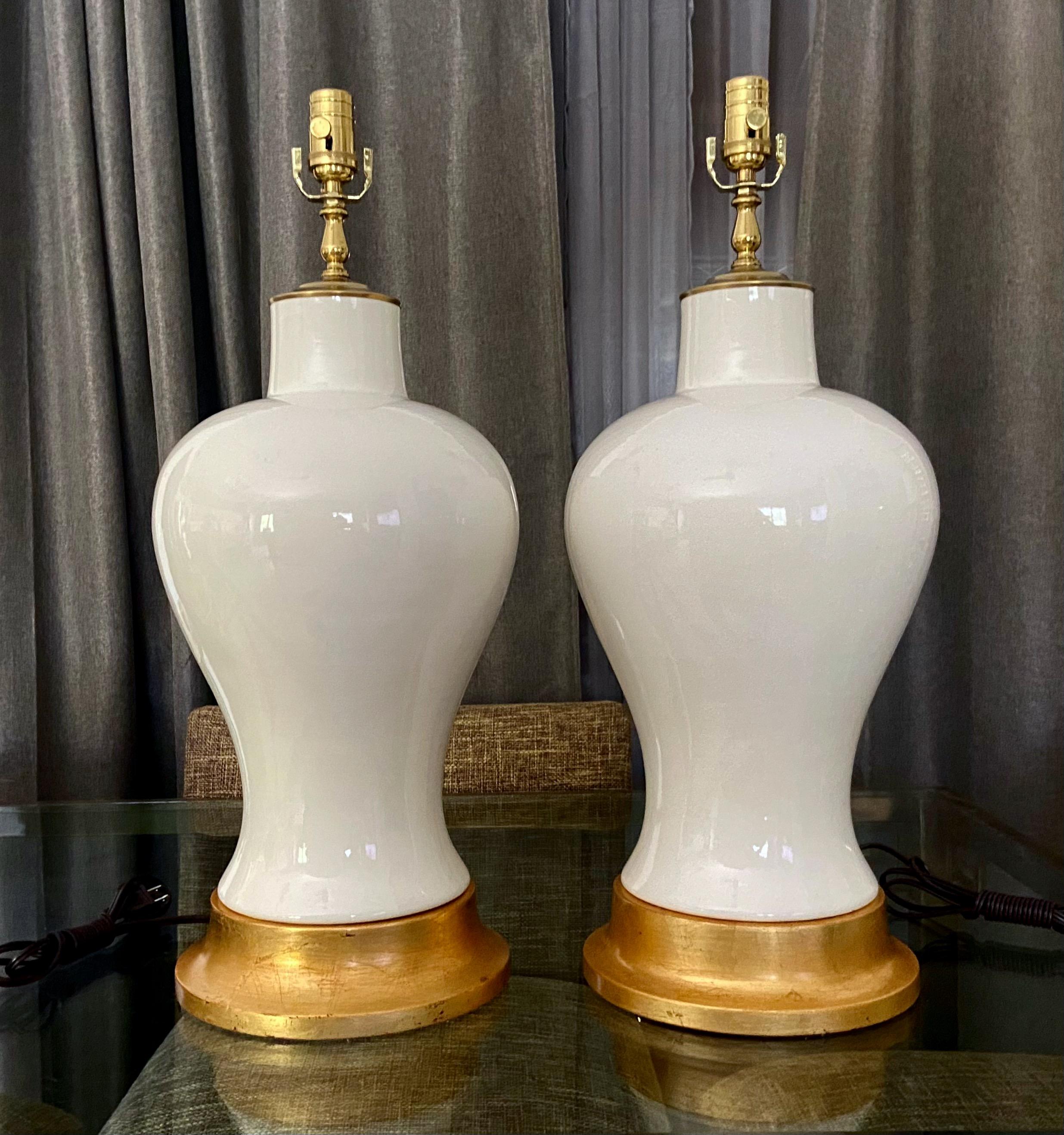 Pair of large white blanc de shine monochrome ginger jar shaped porcelain table lamps. Mounted on turned giltwood bases. Newly wired with new brass 3 way sockets and cords. Overall height top of socket 27