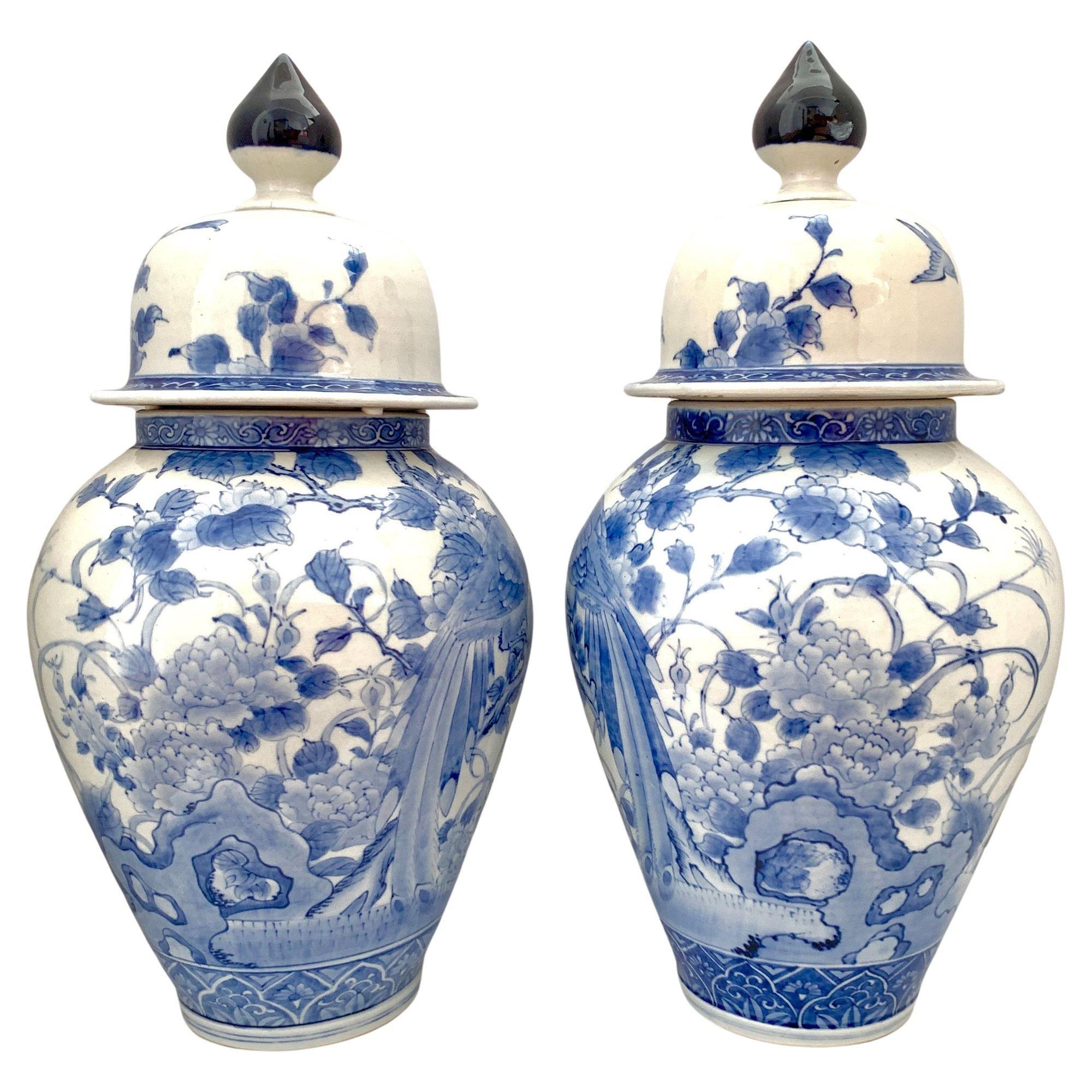 Cette paire de grandes jarres présente un décor raffiné peint à la main en bleu et blanc qui met en scène un oiseau chanteur perché sur un arbre en fleurs. Au-dessus, deux oiseaux sont représentés en vol.
Les jarres sont des reflets l'une de