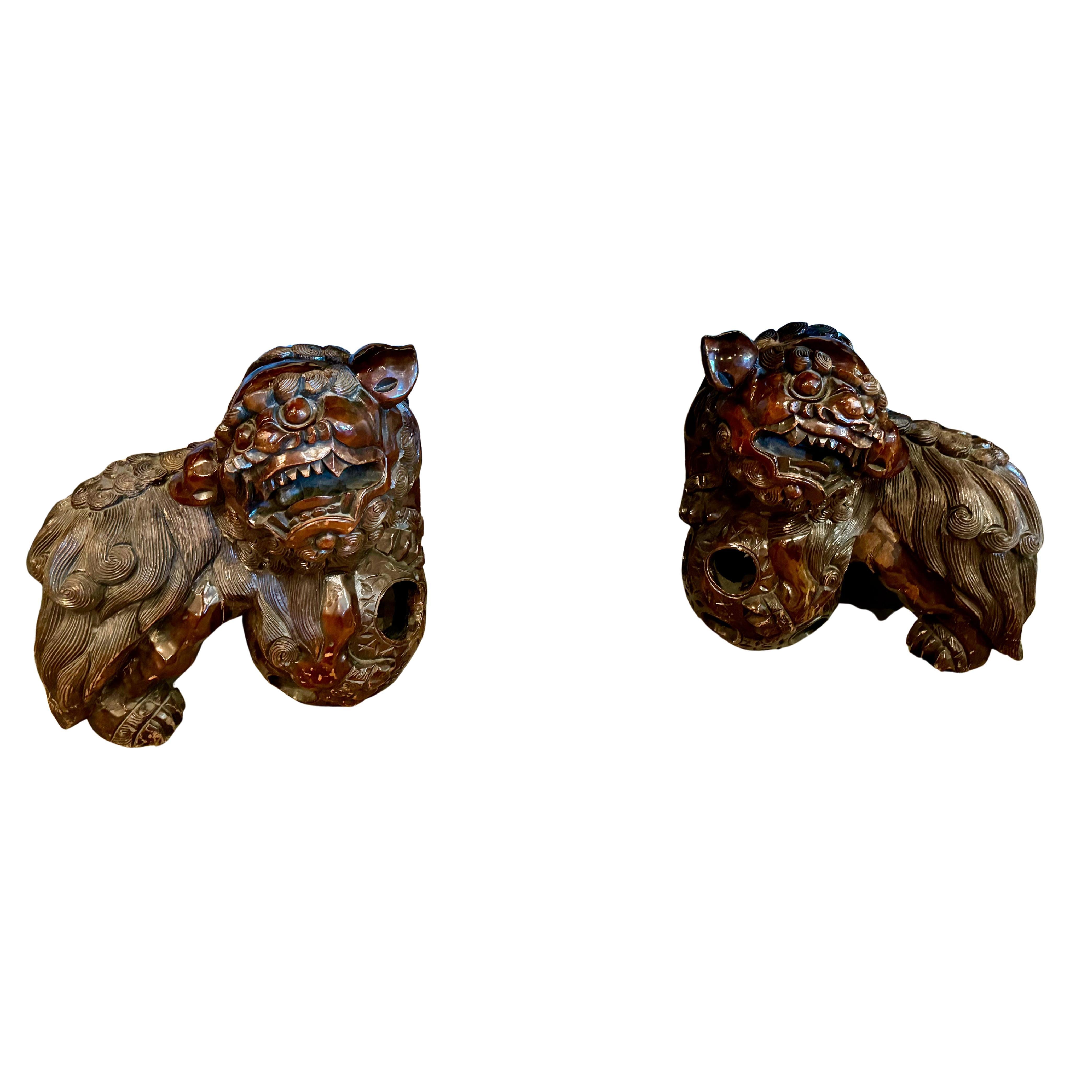 This is a wonderful large pair of mid-20th century carved hardwood fu-lions crafted in the Qing style. Both lions are in very good condition with the anticipated age separations and minor scratches and chips. The lions feature loose pearls in their