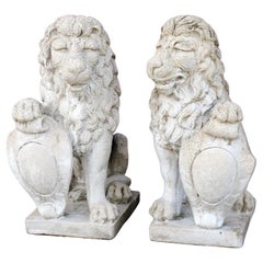 Pareja de grandes leones guardianes de jardín de piedra fundida con escudos, Siglo XX