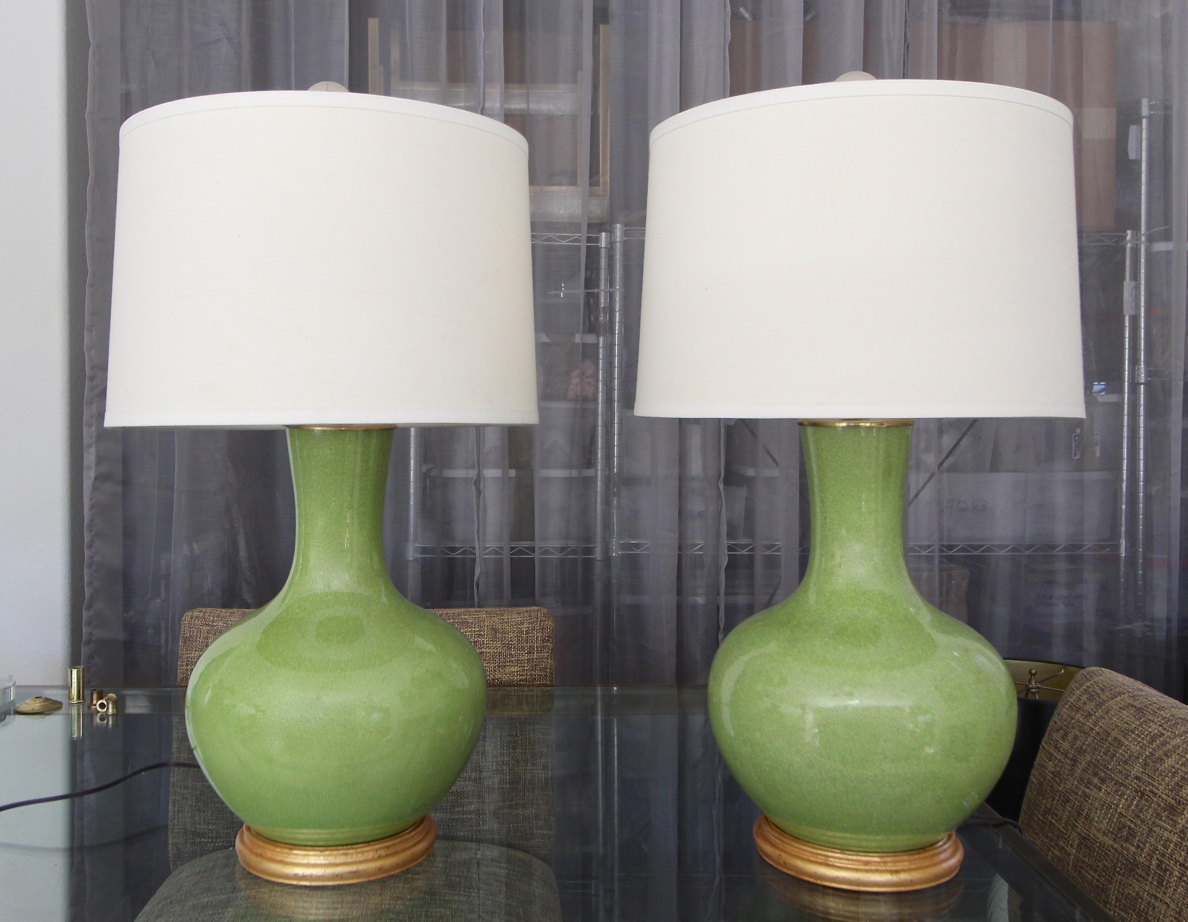 Pair of Chinese apple green porcelain wide baluster form vases mounted on gilt turned wood lamp bases. Newly wired with new 3 way brass sockets and cords. Vase portion with base 17.5