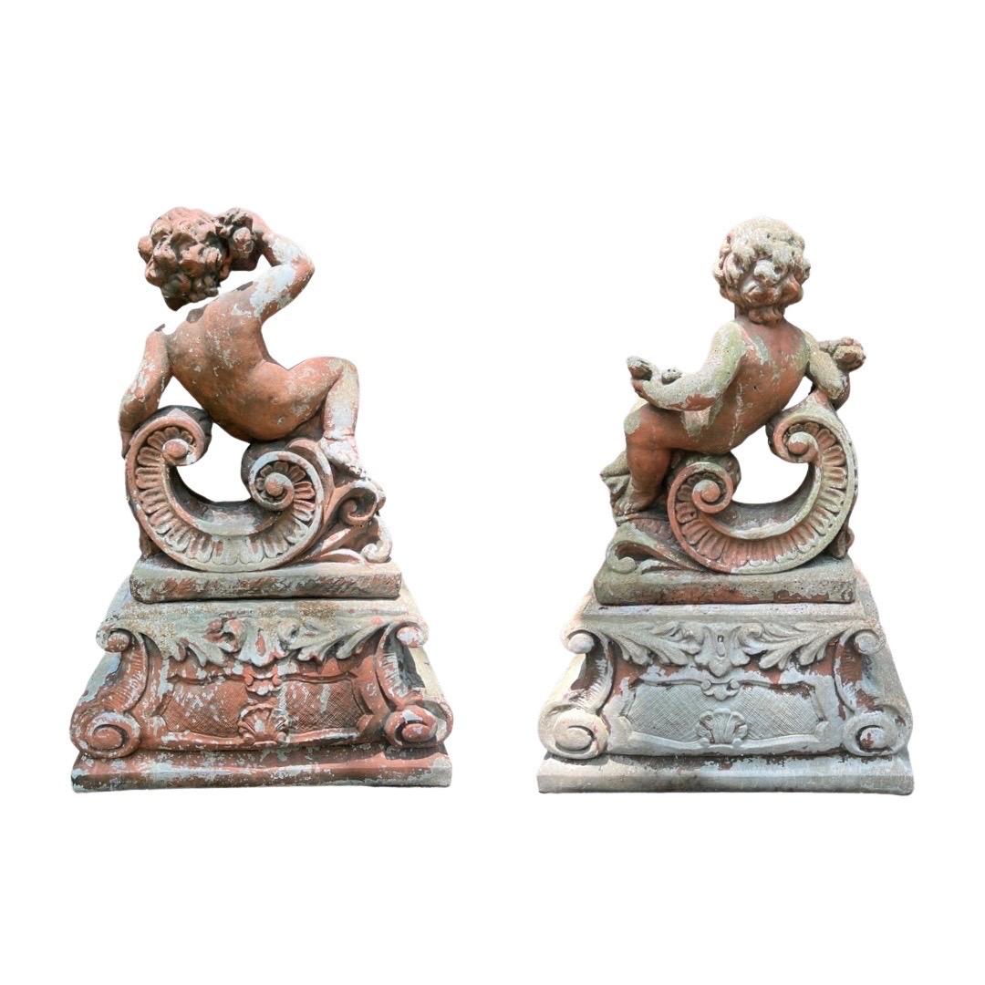 A spectacular pair of French garden statues with a Renaissance Revival or Classical form. Traditional figures in form, depicting Putti forms - each holding grapes and a sheaf of wheat respectively, they have reclining nude bodies on a C form