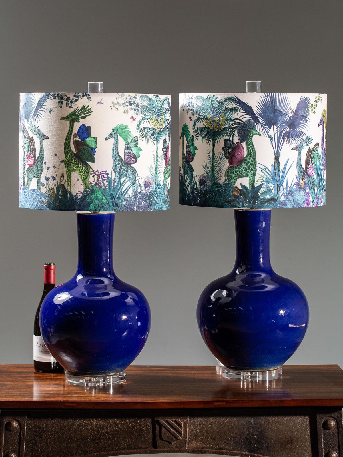 A pair of stunning intensely colored cobalt blue handmade vase lamps each mounted on a lucite base and fitted with a custom designed lampshade created by an English artist. Please enlarge all the photographs to see the lamps in close up detail,