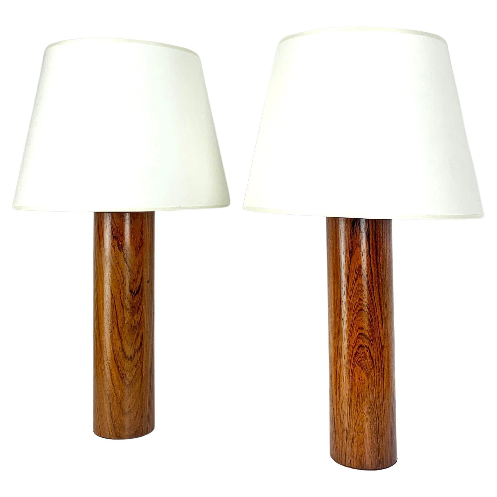 A pair of architectural table lamps. Lamp foots in wood, probably teak. 

Designed by Uno Kristiansson, for Luxus, Sweden, 1970s. Both retain their original labels: made in Sweden - Luxus Vittsjö - Design Uno & Östen Kristiansson.

For E26/27 bulbs.