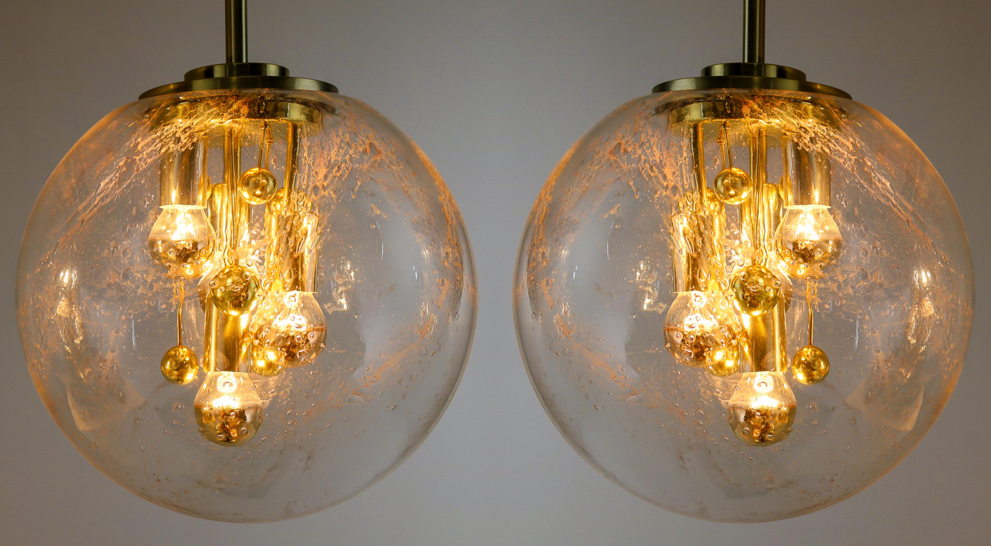 Pair of large Doria globe pendant lights, art-glass and brass, Germany 1970s. These heavy quality light sculptures not only function as light sources but also as a sculptural components. The arrangement is reminiscent of the Atomium structure in