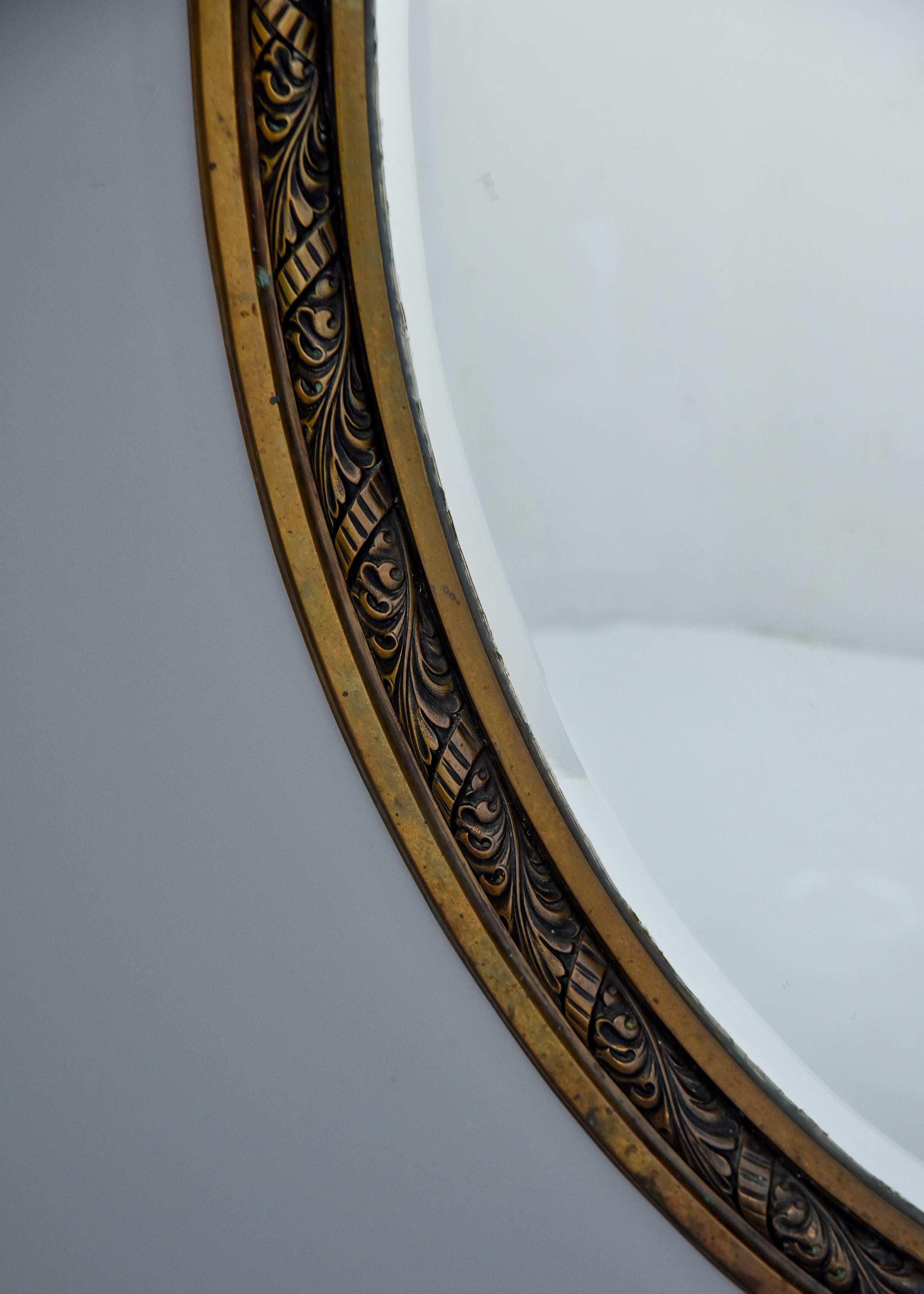 Français Paire de grands miroirs en bronze à cadre ovale et bords biseautés du début du 20e siècle.  en vente