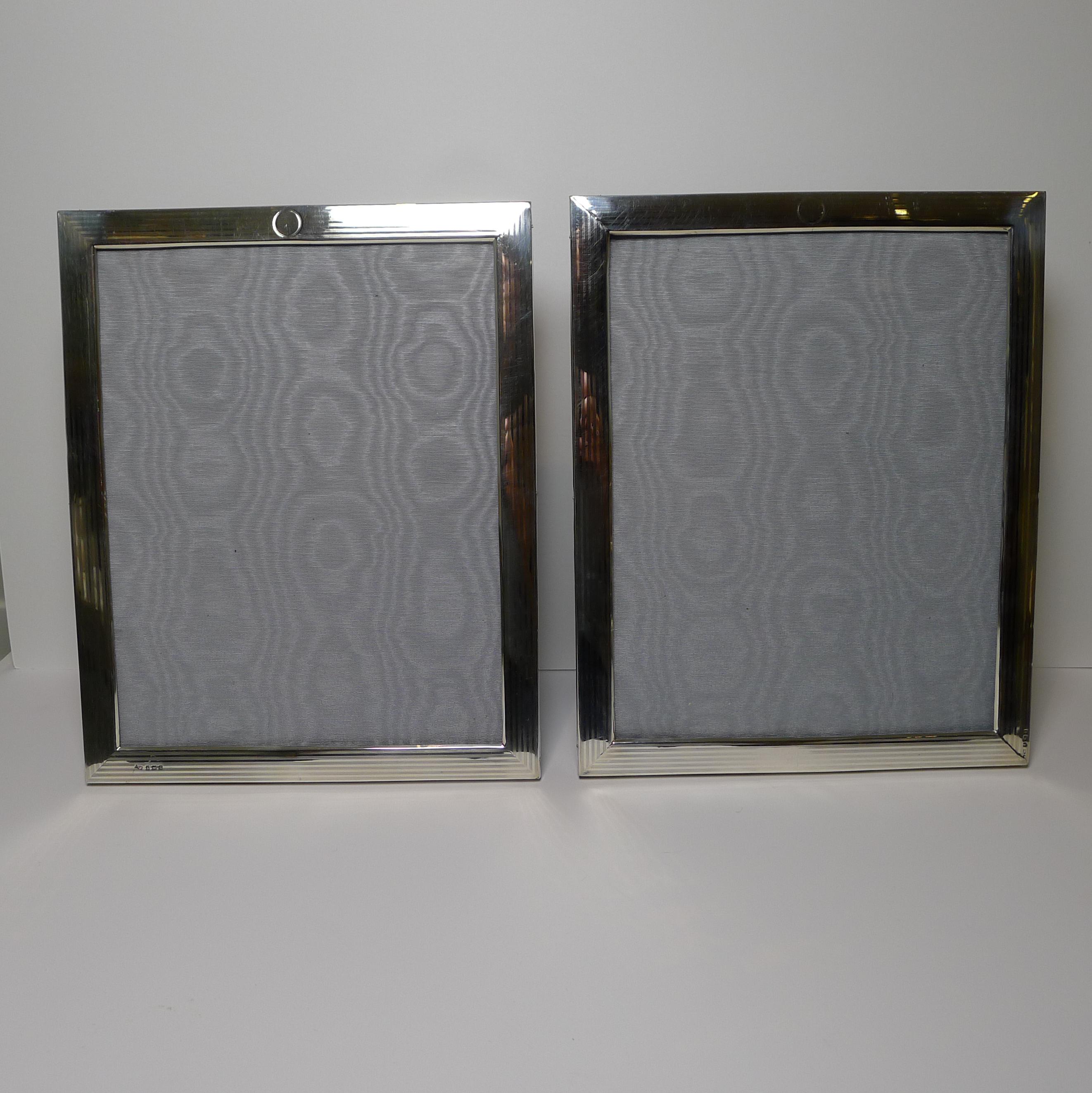 So lovely to find a pair of large sterling silver picture frames with smart linear engine turned decoration each with a small circular vacant cartouche to the top.

The backs are made from solid English Oak with a folding easel stand. The silver
