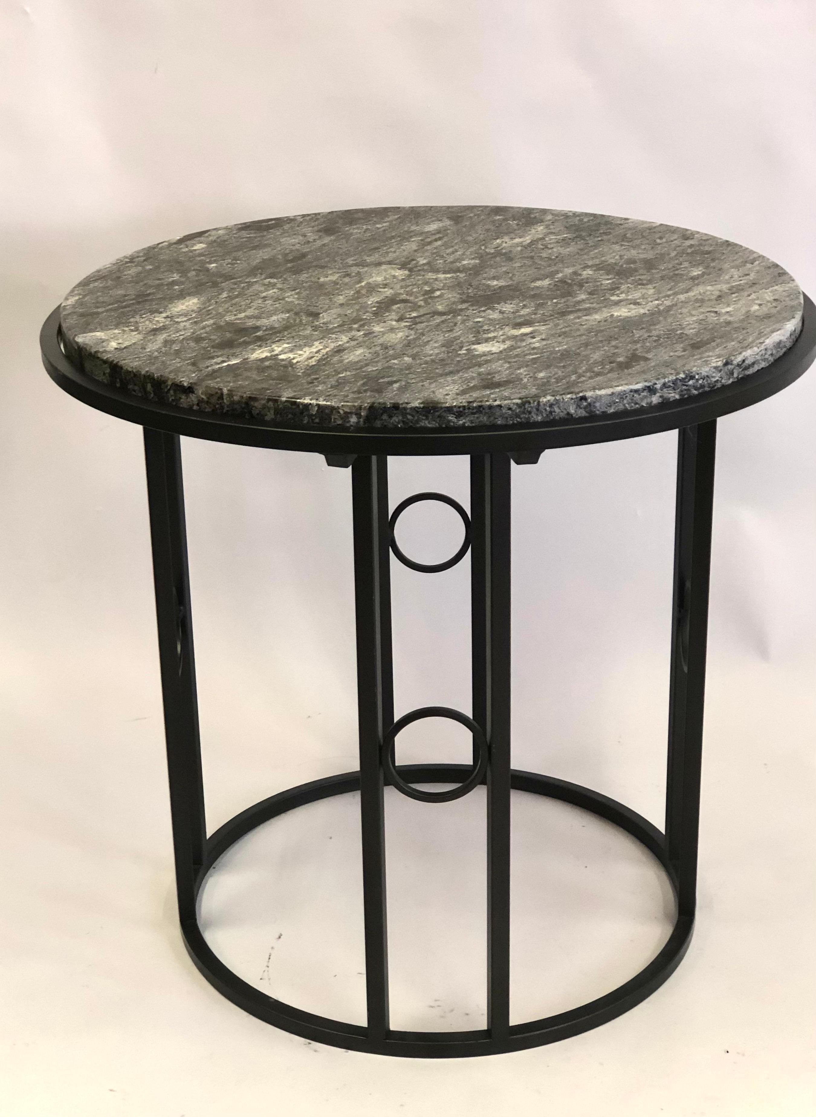 Pair of French 1930 Late Art Deco / Modern Neoclassical side or end tables. The tables offer a sober, pure, minimal presentation. The wrought iron bases are arranged in a circular form with 4 pairs of iron bar supports each united by interior round